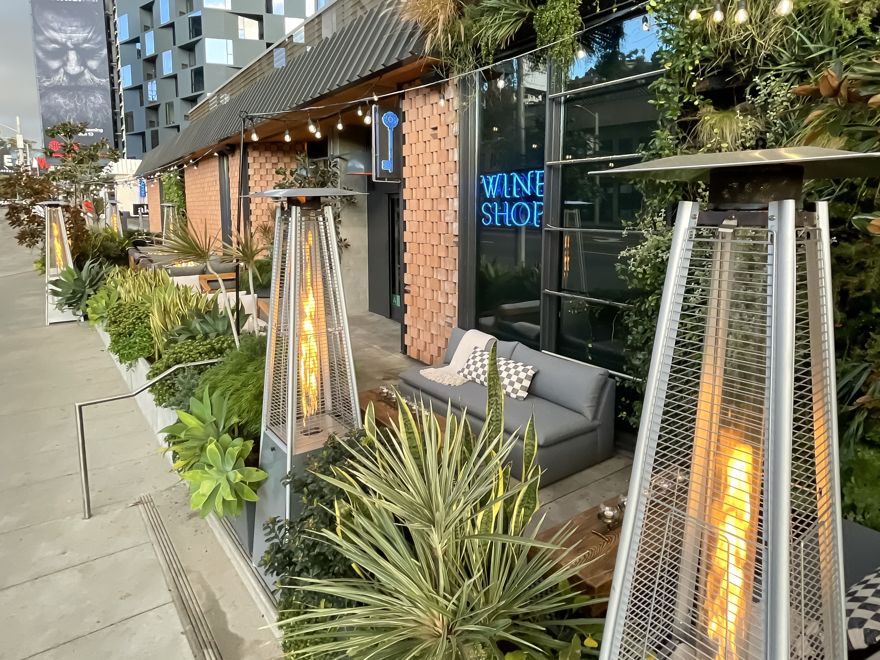 An outdoor seating area with heat lamps, sofas, and chairs at Boutellier wine bar in West Hollywood, California.