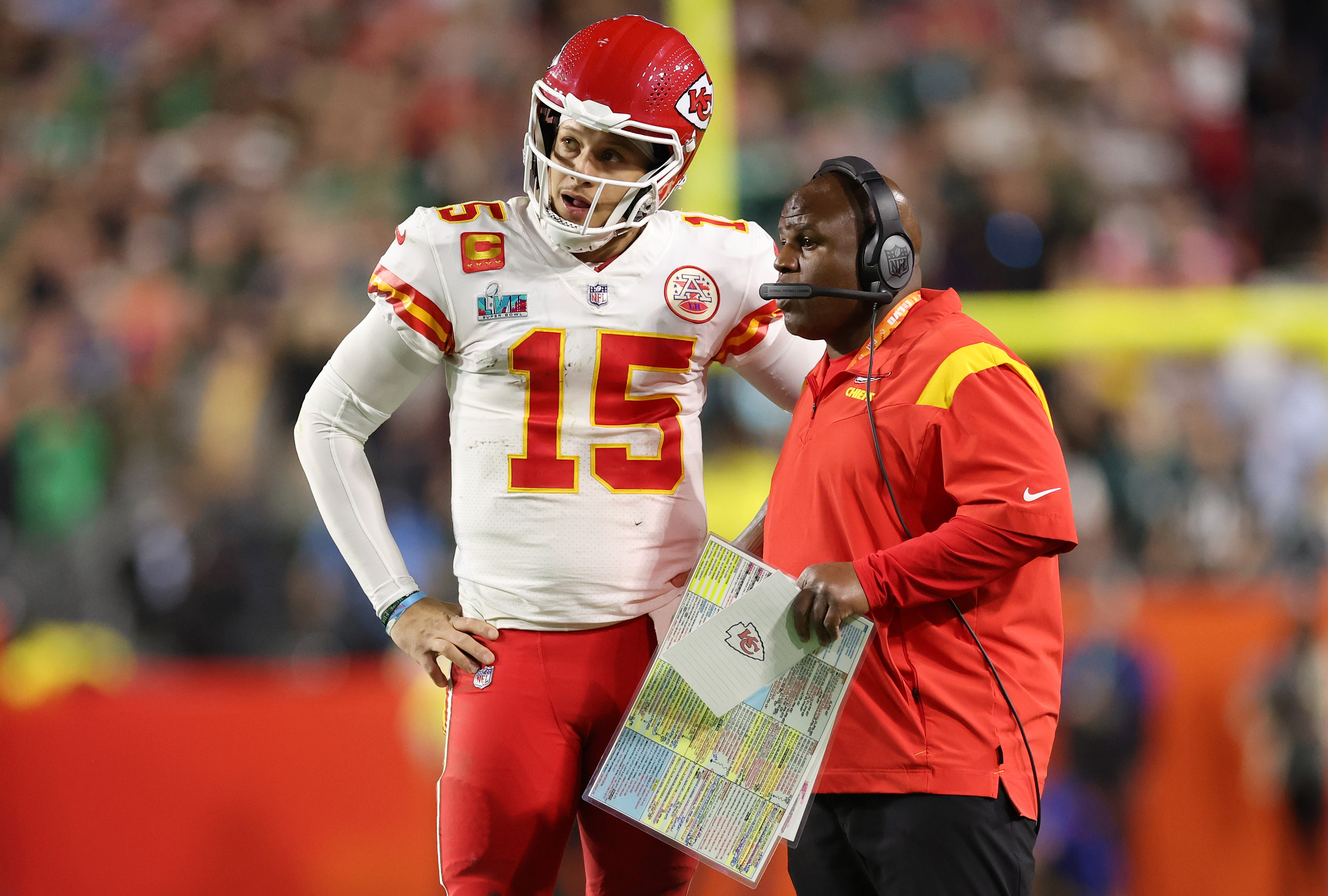 Patrick Mahomes of the Kansas City Chiefs talks with offensive coordinator Eric Bieniemy during the fourth quarter against the Philadelphia Eagles in Super Bowl LVII at State Farm Stadium on February 12, 2023 in Glendale, Arizona.