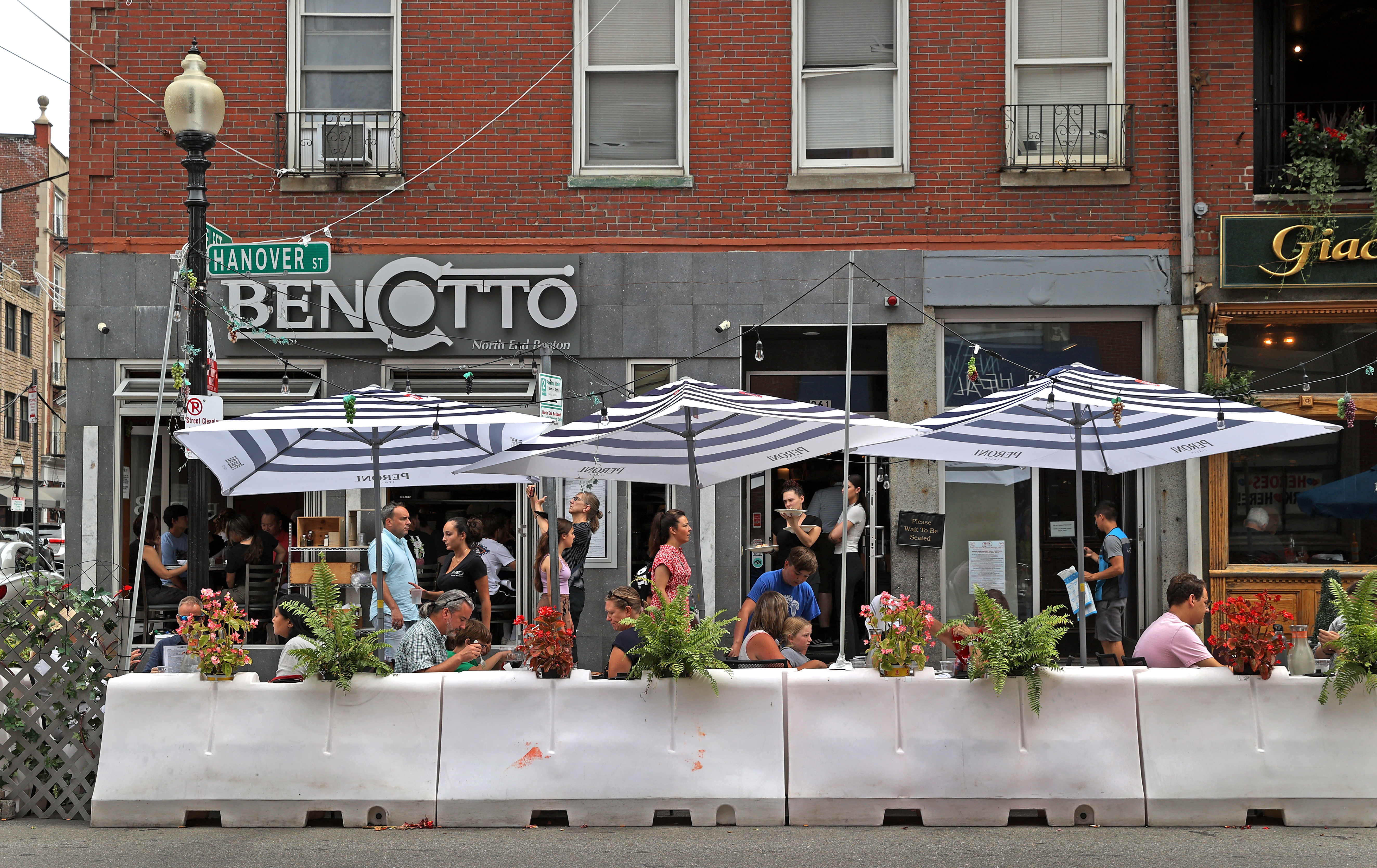 Crowds of people enjoy outdoor dining outside of Bencotto in the North End of Boston.