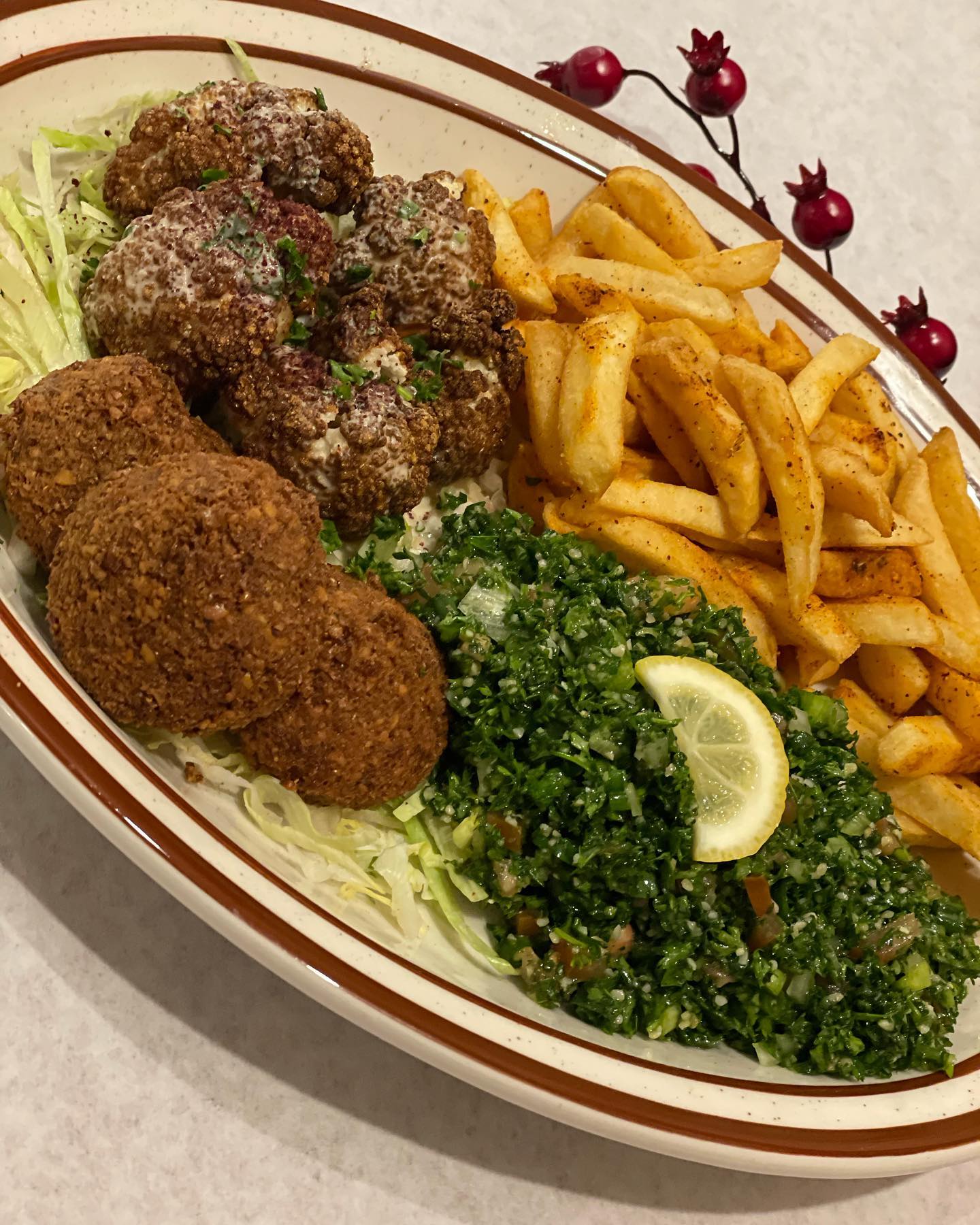 A plate of falafel and fries and rice and salad.