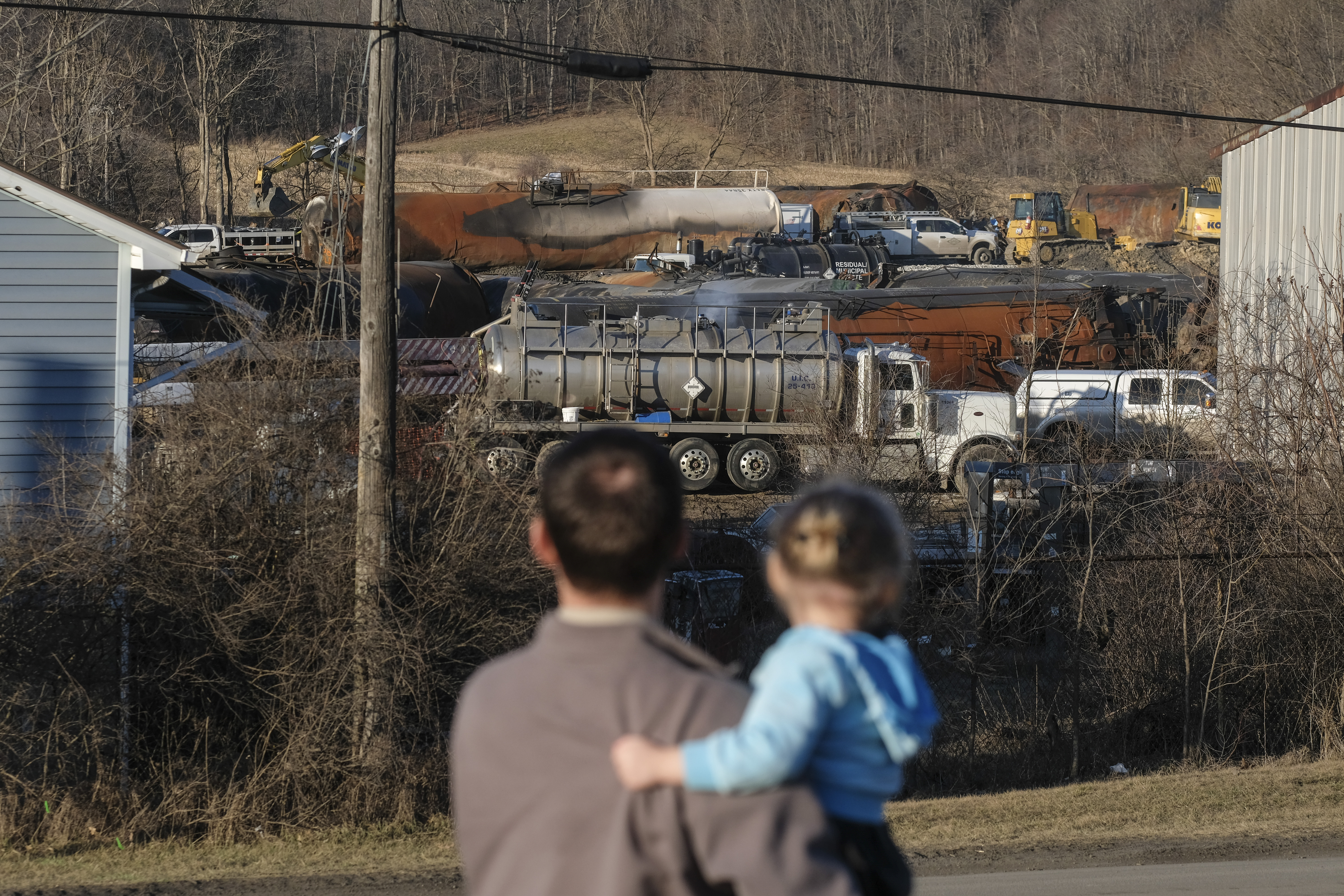 A family from Pennsylvania inspects the wreckage of the Norfolk Southern train derailment in East Palestine, Ohio, on February 19, 2023.