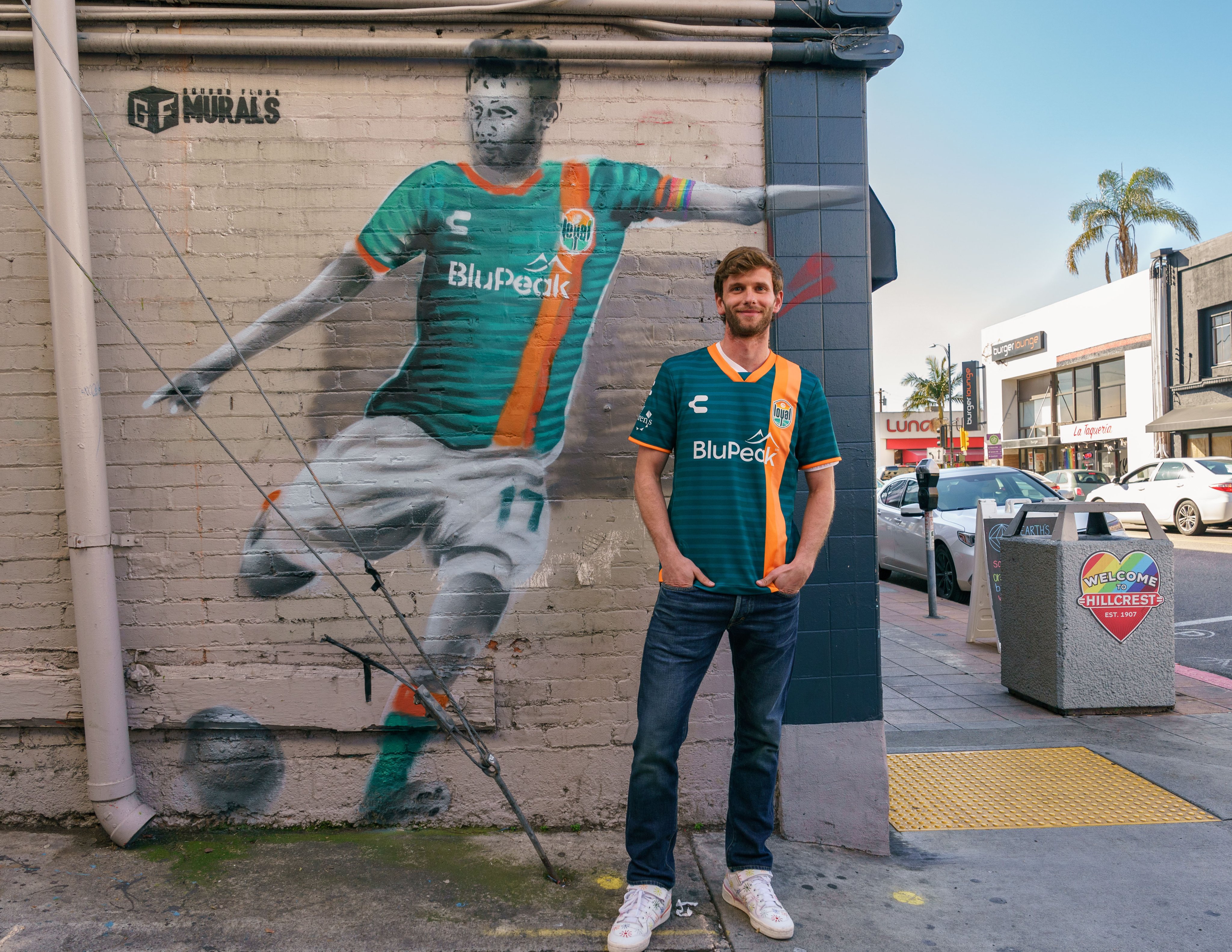 Collin Martin of the San Diego Loyal stands in front of a mural of himself.