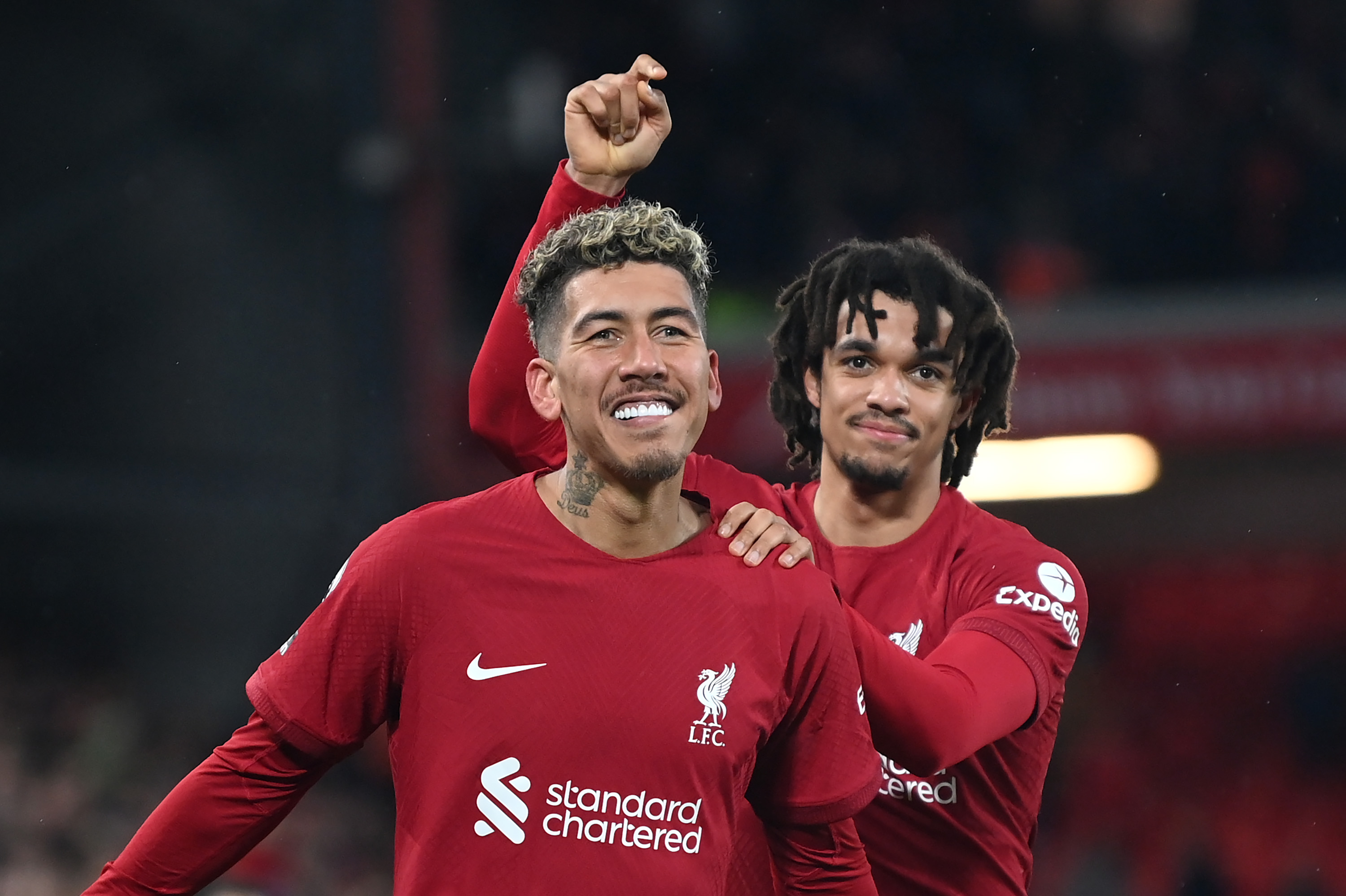 Roberto Firmino of Liverpool celebrates after scoring the team’s seventh goal with teammate Trent Alexander-Arnold during the Premier League match between Liverpool FC and Manchester United at Anfield on March 05, 2023 in Liverpool, England.