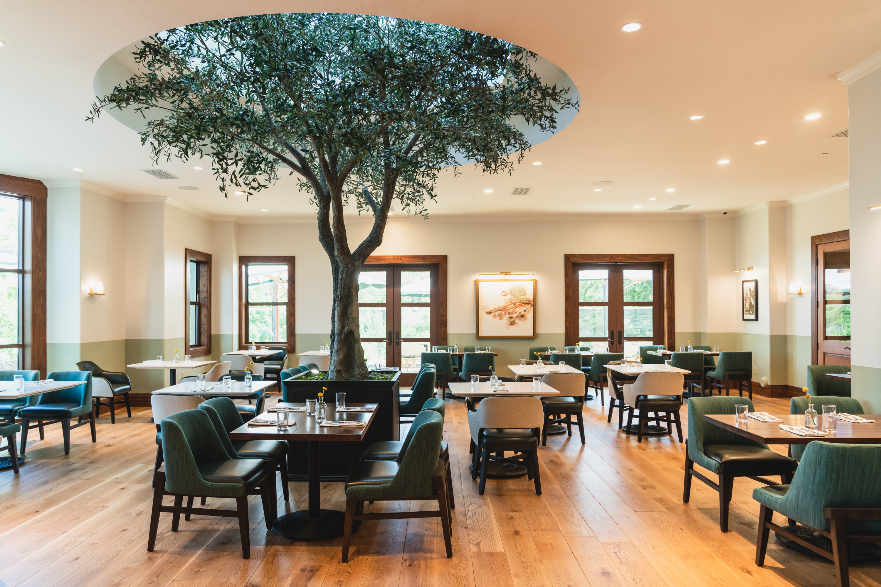 A restaurant dining room with a tree in the middle.