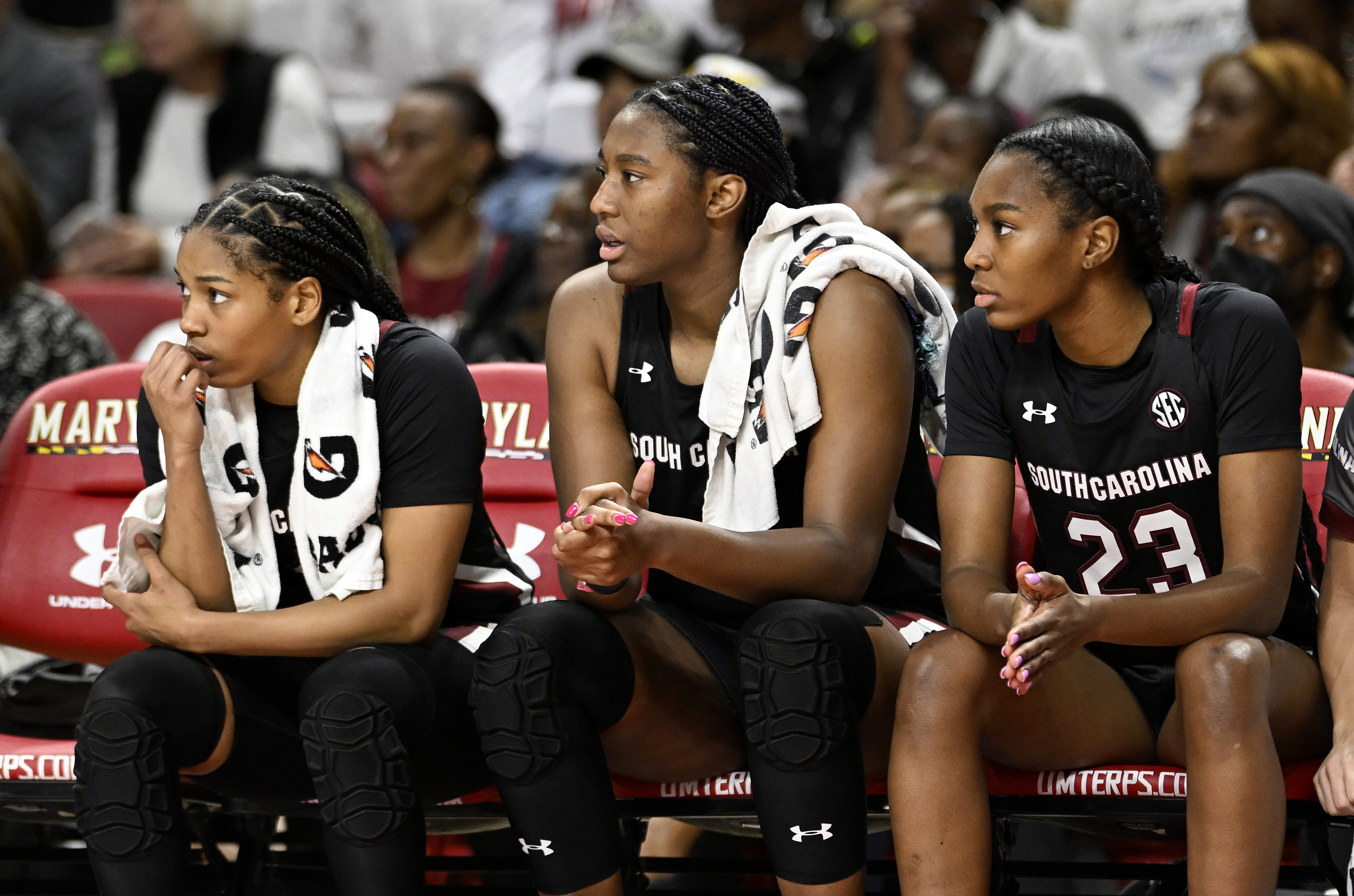 Aliyah Boston #4, Zia Cooke #1 and Bree Hall #23 of the South Carolina Gamecocks watch the game against the Maryland Terrapins at Xfinity Center on November 11, 2022 in College Park, Maryland.
