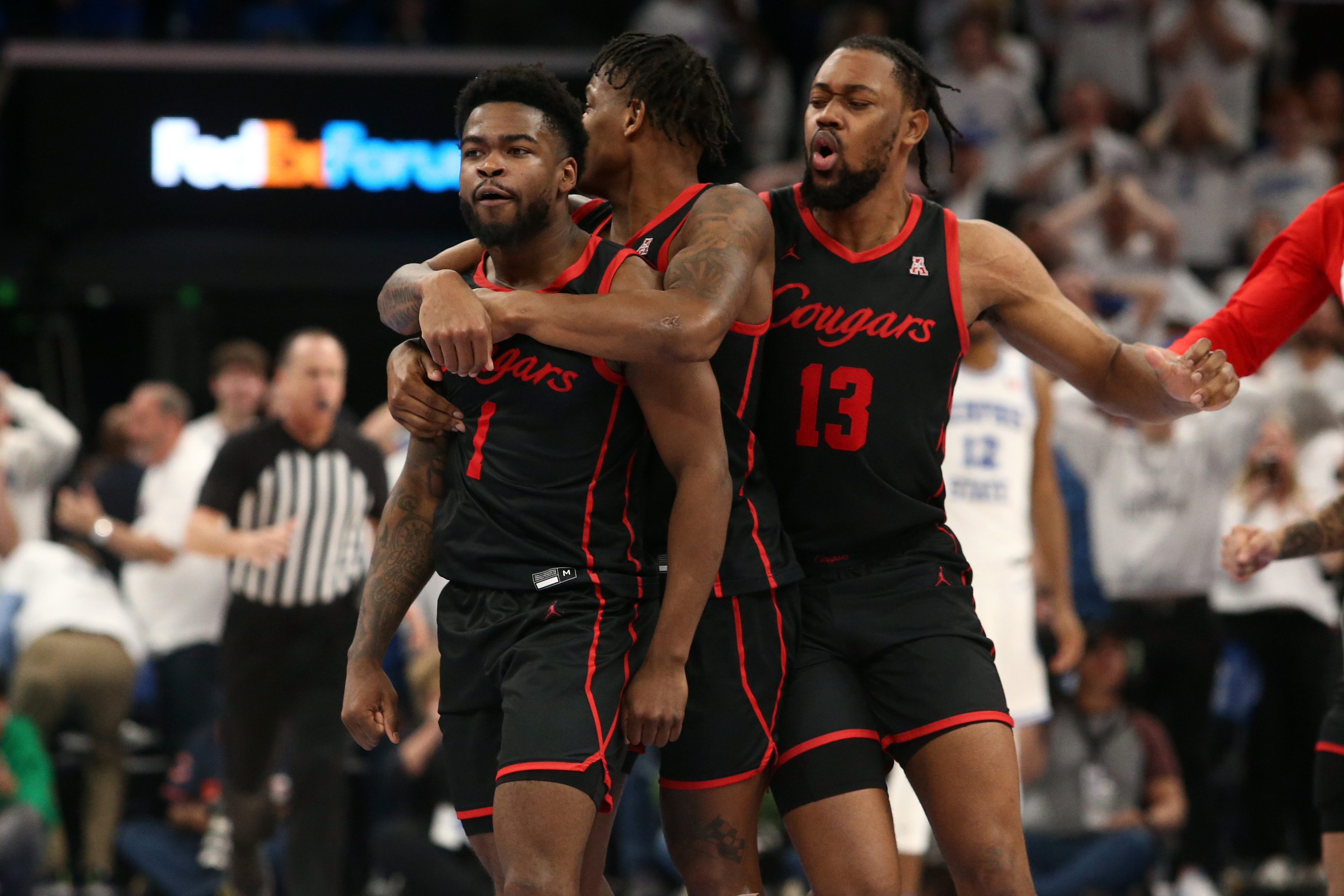 Houston Cougars guard Marcus Sasser (0) and forward J’Wan Roberts (13) reacts with guard Jamal Shead (1) after he scored the game winning basket against the Memphis Tigers at FedExForum.&nbsp;