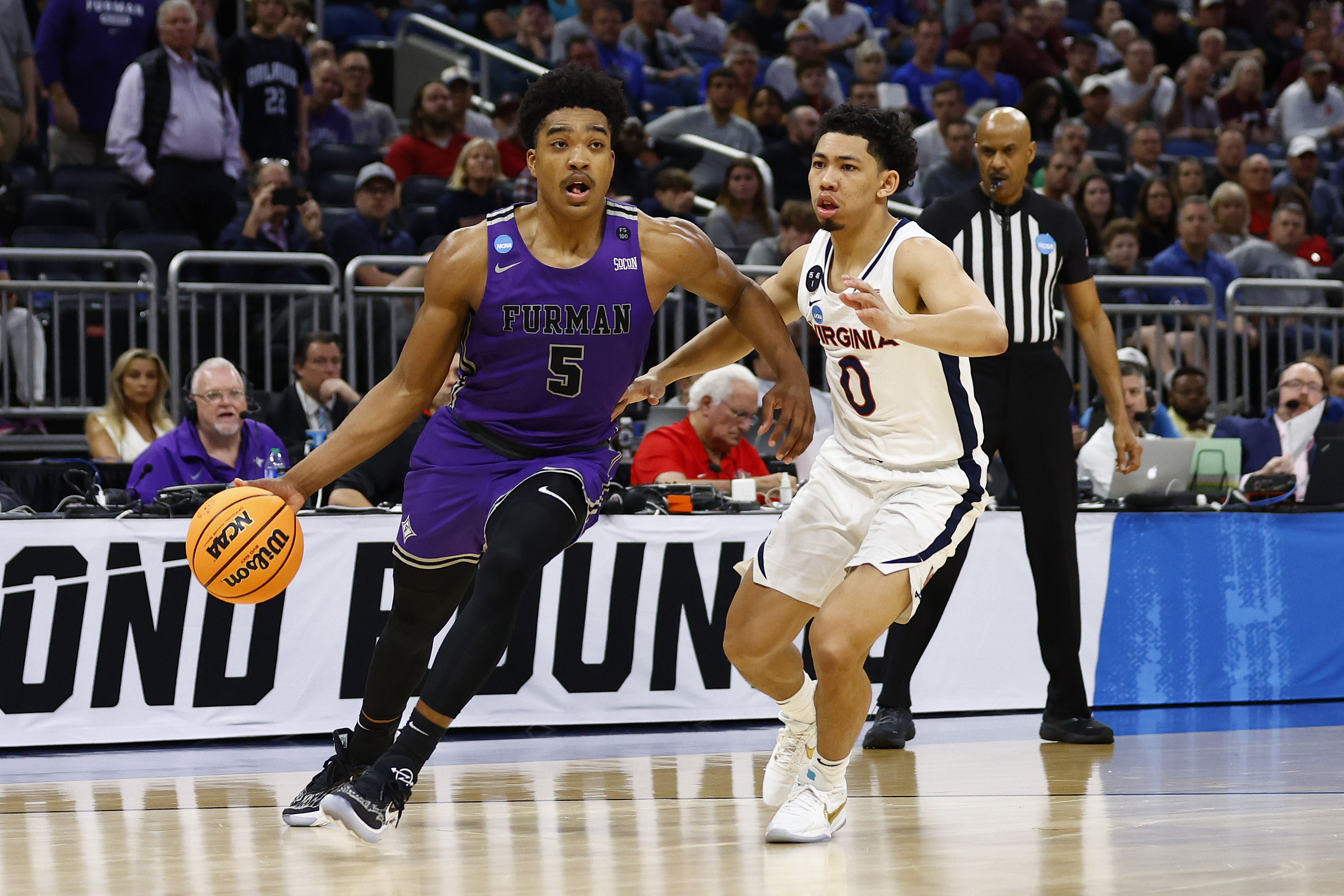 Marcus Foster of the Furman Paladins dribbles the ball against Kihei Clark #0 of the Virginia Cavaliers during the second half in the first round of the NCAA Men’s Basketball Tournament at Amway Center on March 16, 2023 in Orlando, Florida.