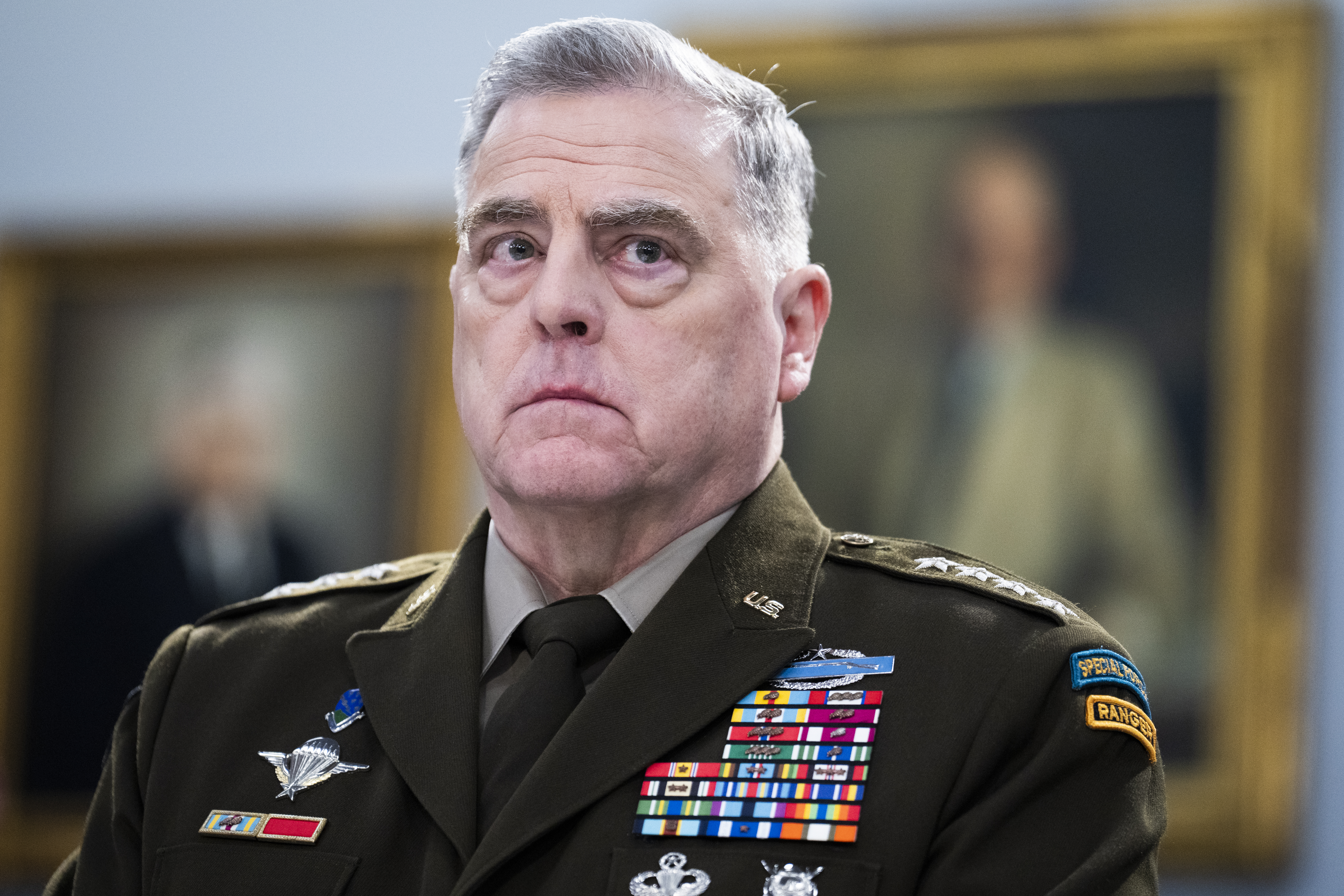 General Mark Milley wears a serious expression, dressed in military uniform with colorful medals and pins.