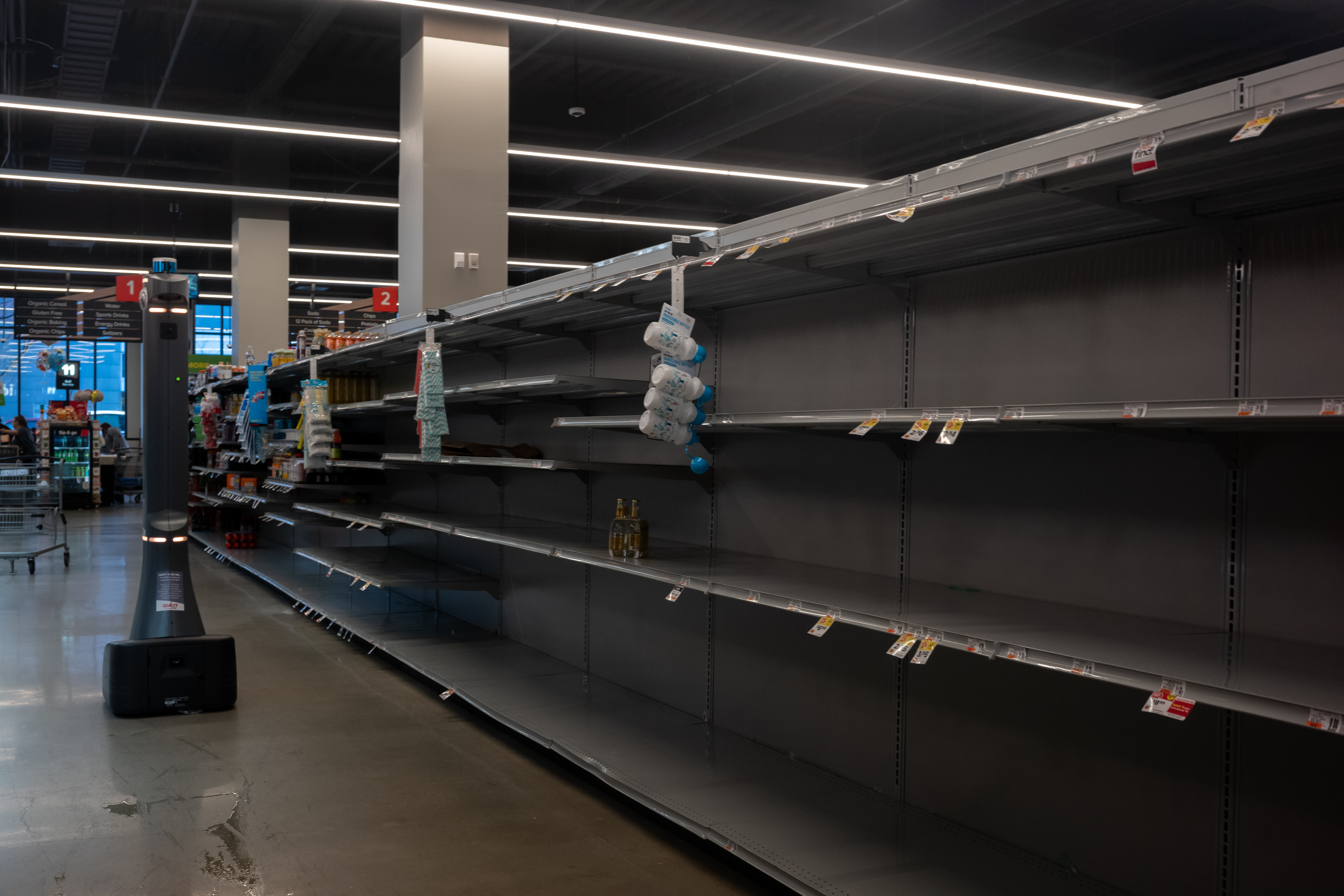 Empty shelves in a grocery aisle.