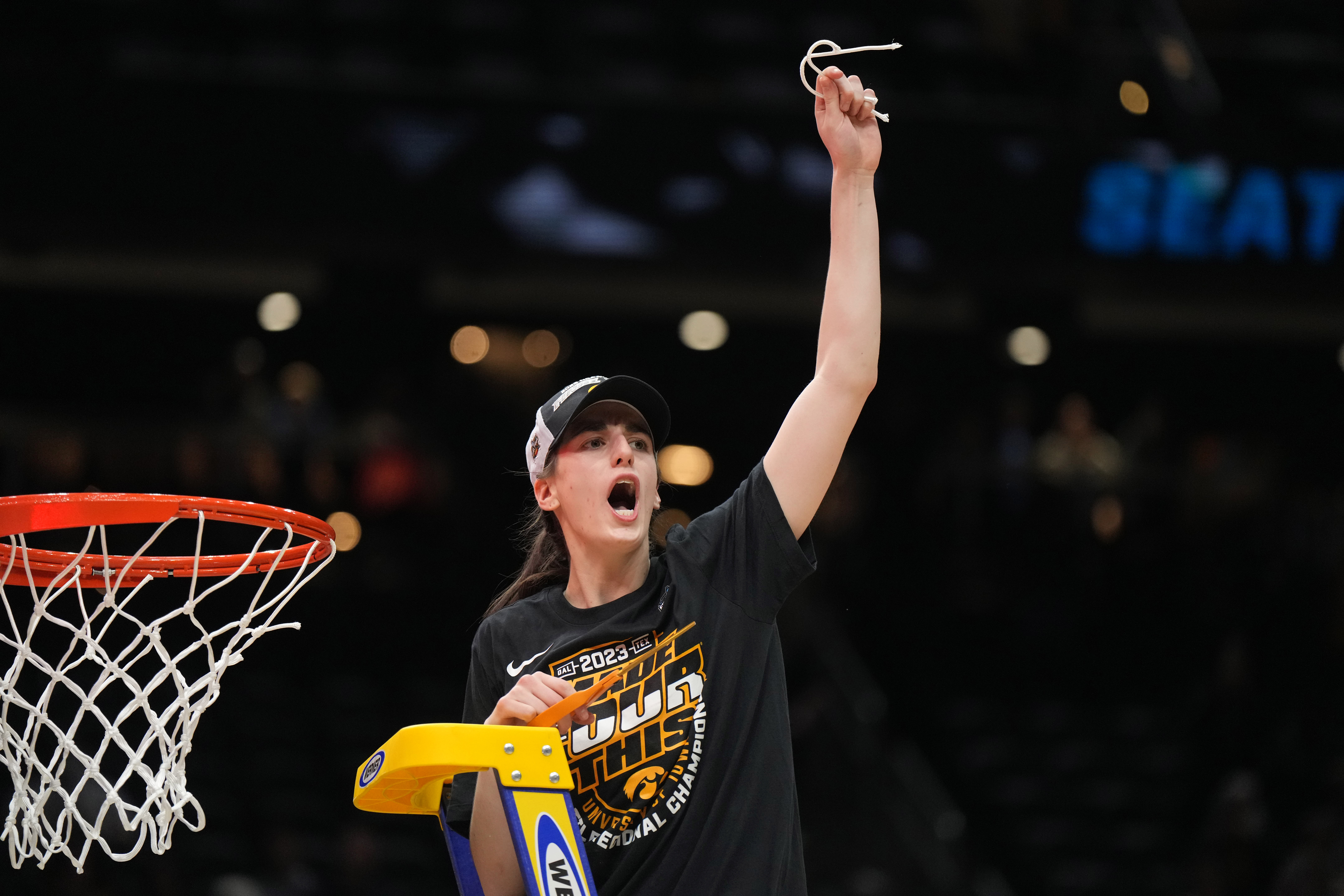 Iowa Hawkeyes guard Caitlin Clark celebrates after cutting the net after the game against the Louisville Cardinals at Climate Pledge Arena.
