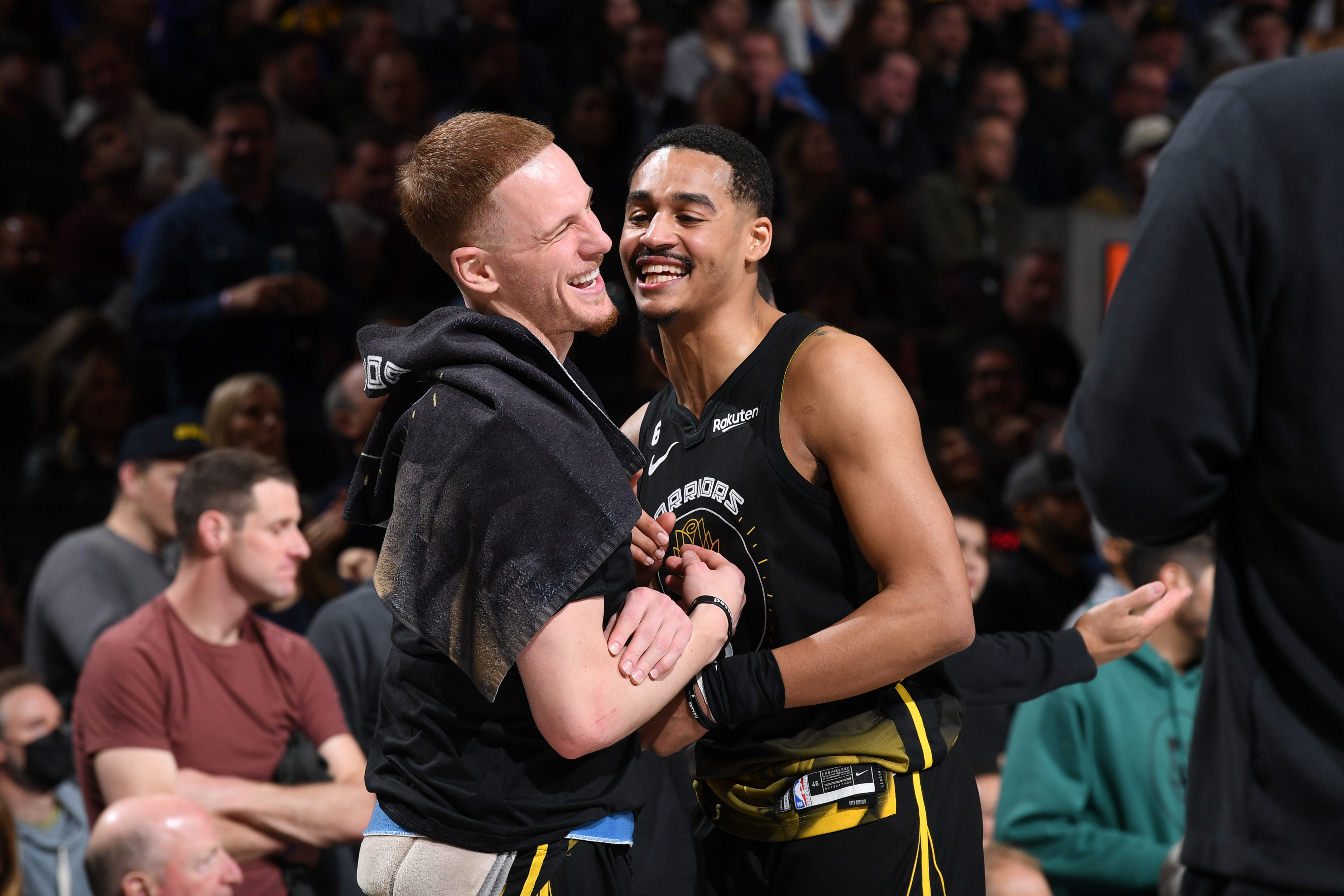 Jordan Poole and Donte DiVincenzo laughing and hugging 