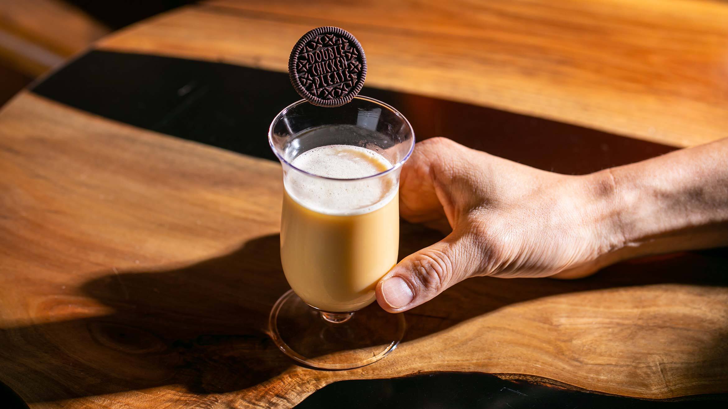 A milky cocktail garnished with an Oreo