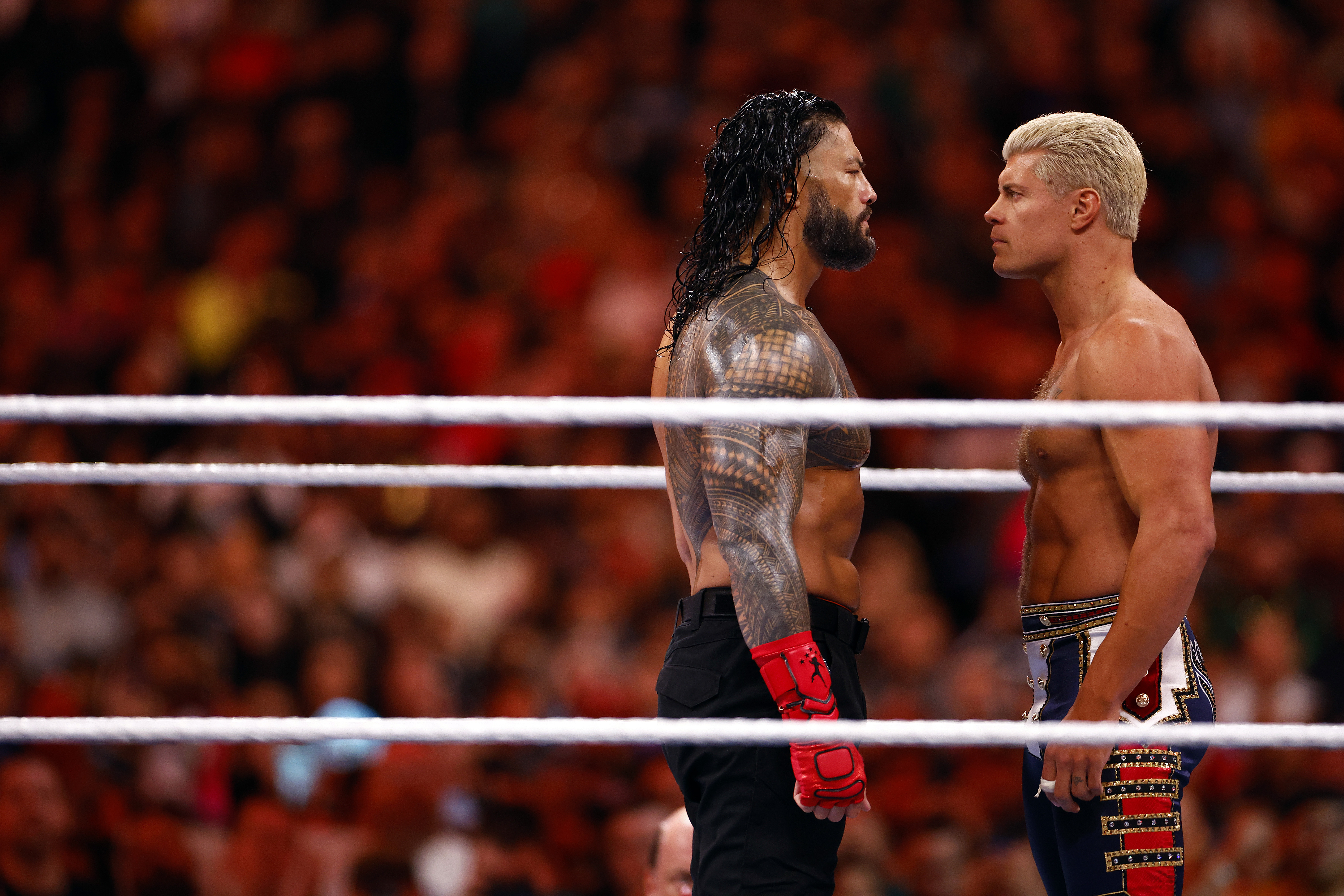 Roman Reigns and Cody Rhodes staring each other down in the ring at WrestleMania 39.
