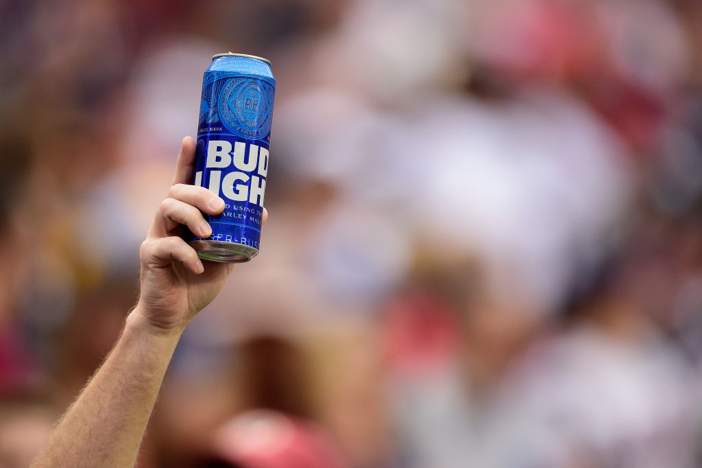 A person’s hand holding up a can of Bud Light.