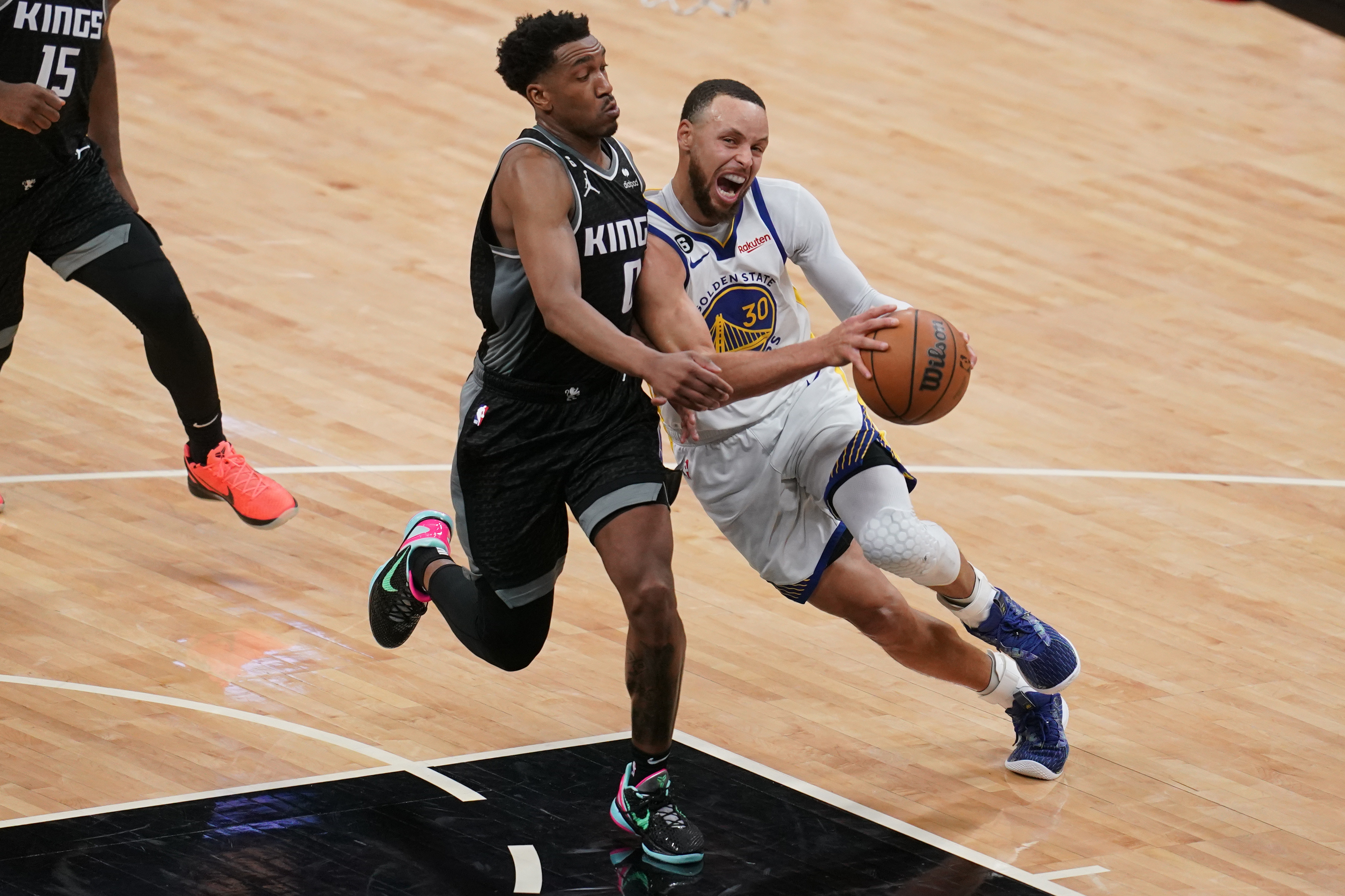 Steph Curry driving while defended by Malik Monk 