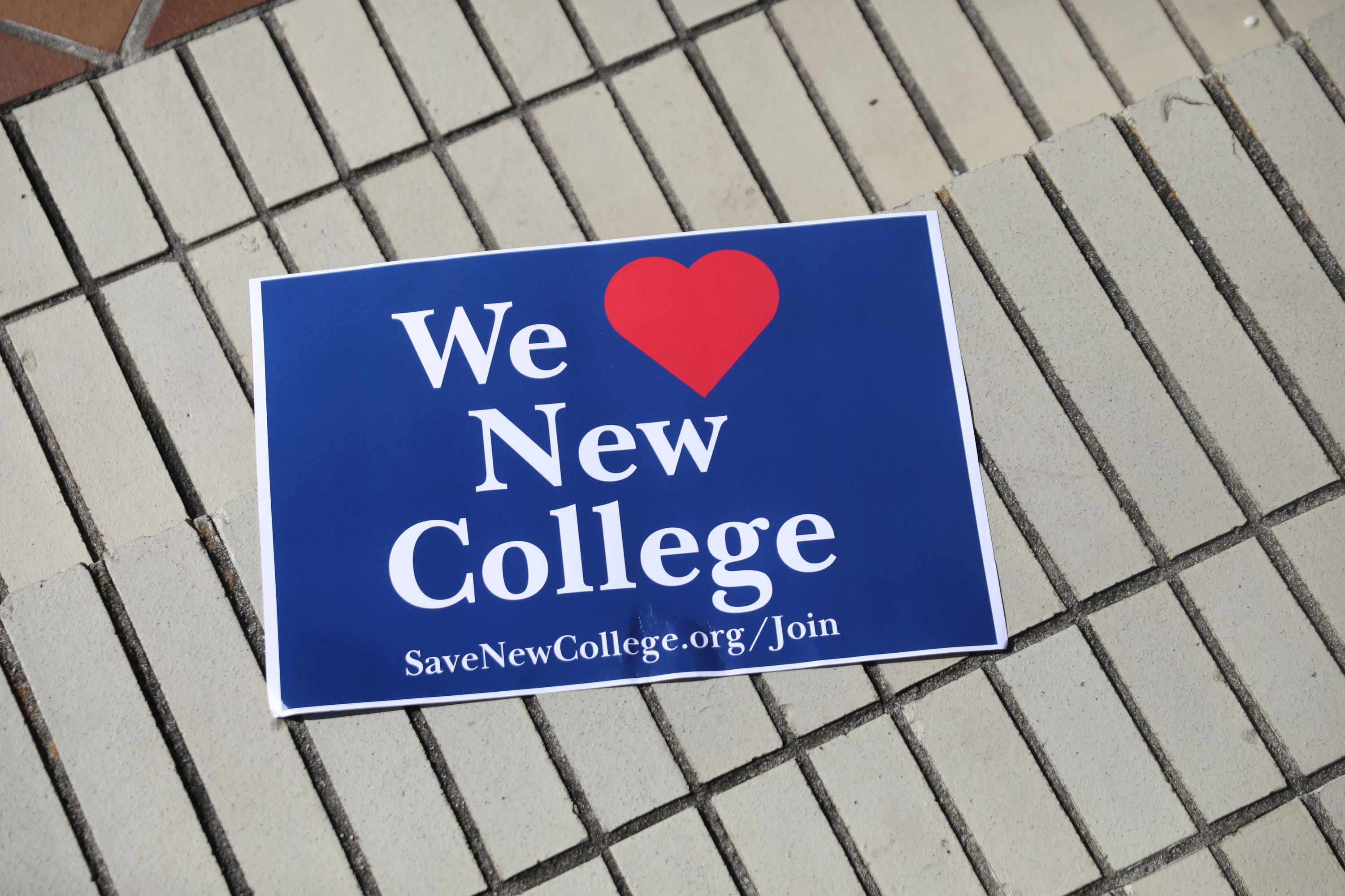 A blue sticker that says We Heart New College.