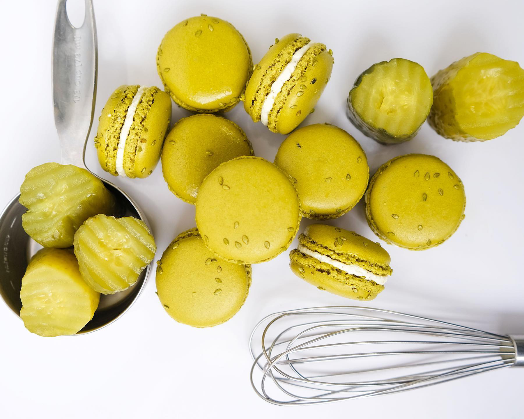 Green macarons with a bowl of pickle slices.
