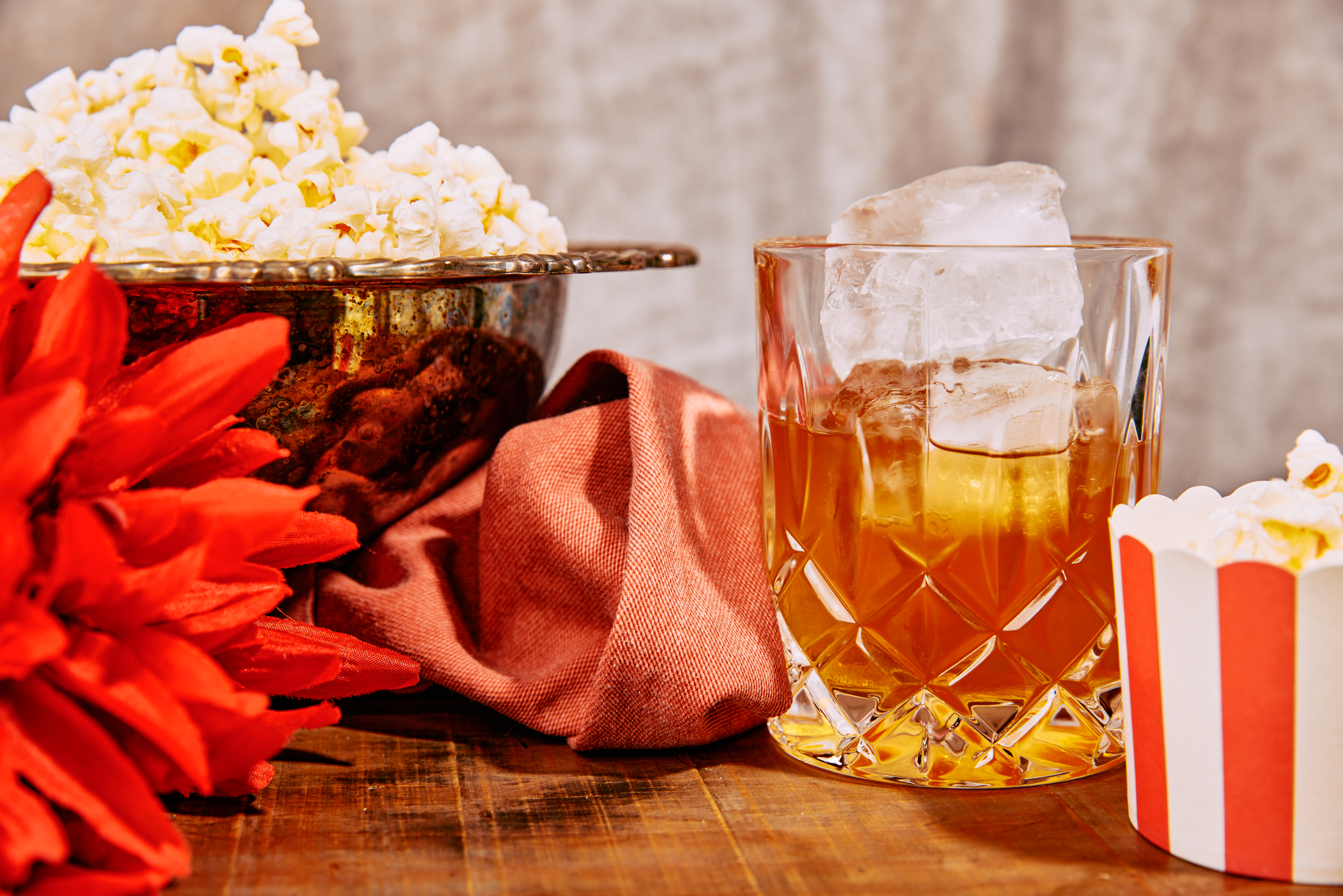 A buttered popcorn Old Fashioned sits next to a bowl of popcorn at The End.