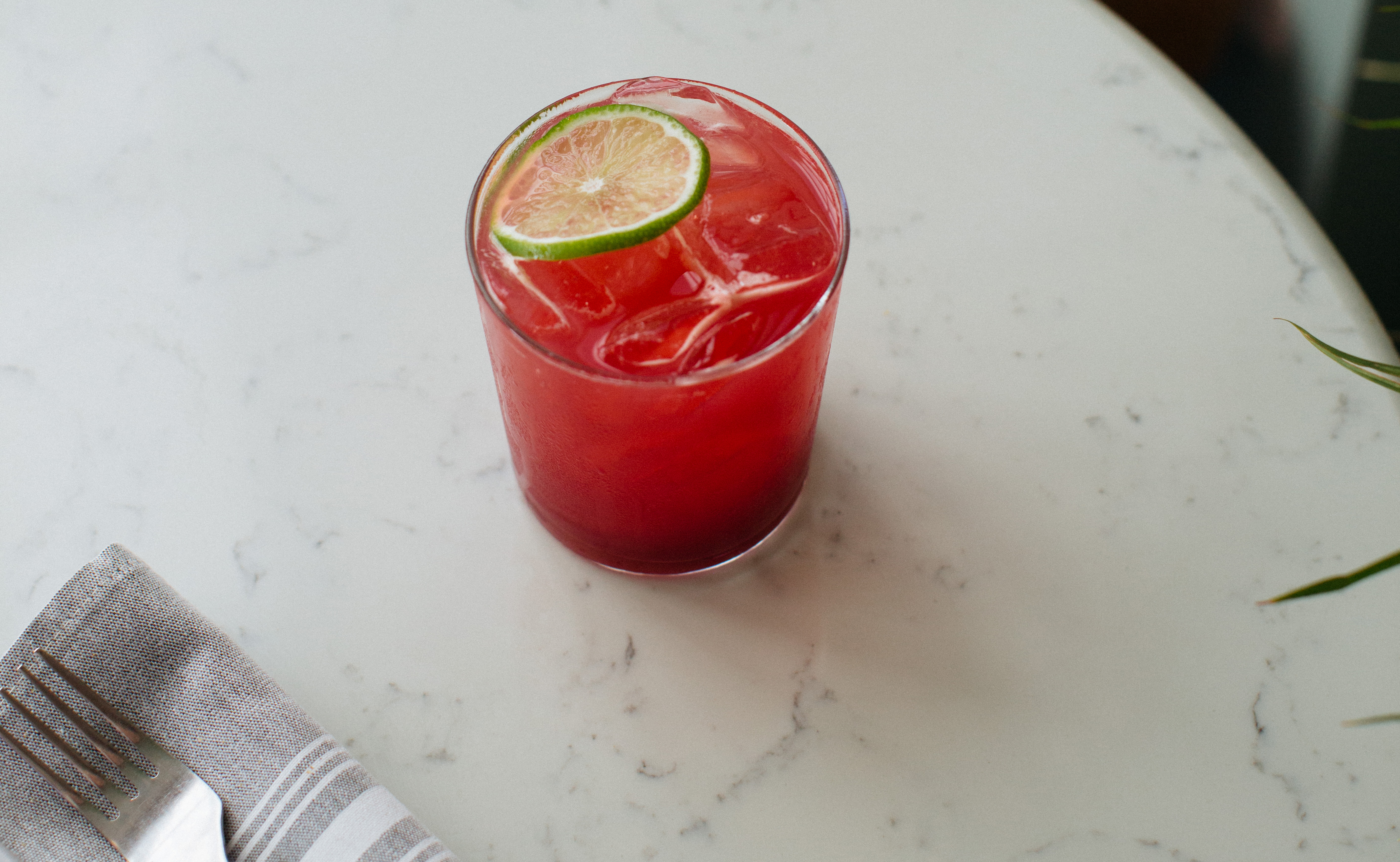 A red margarita on a white marble surface. 