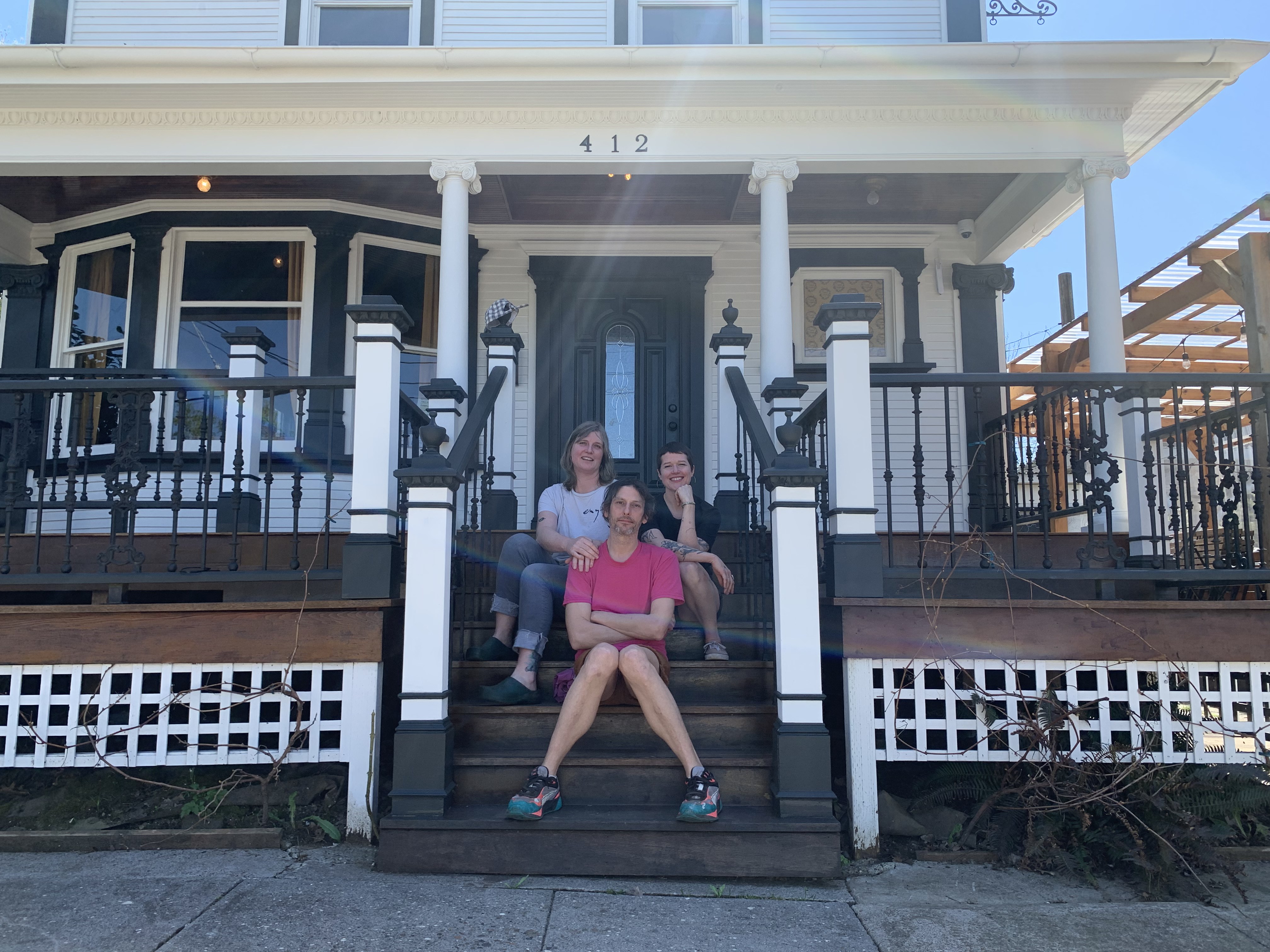 Ami Taylor, Brighid King, and Tony Lambright sit on the steps of Dream House in Portland, in the former Beech Street Parlor space. 