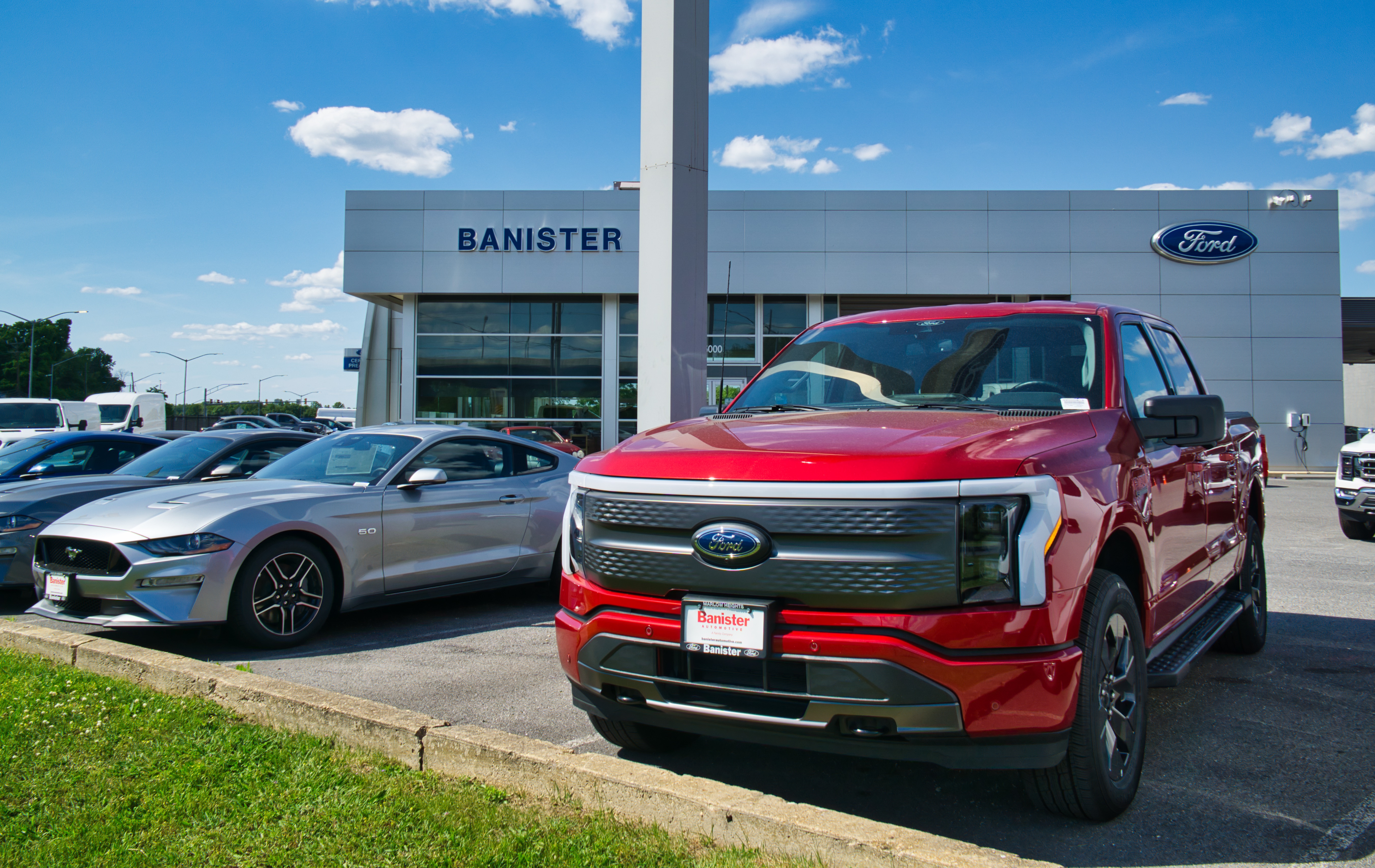 Photo of red Ford F-150 EV outside of a dealership