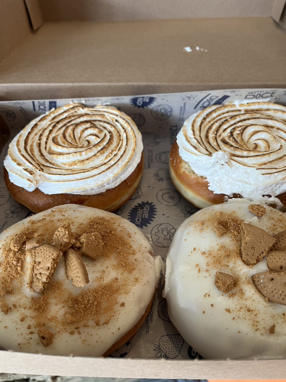Four doughnuts topped with frosting and cookie bits.