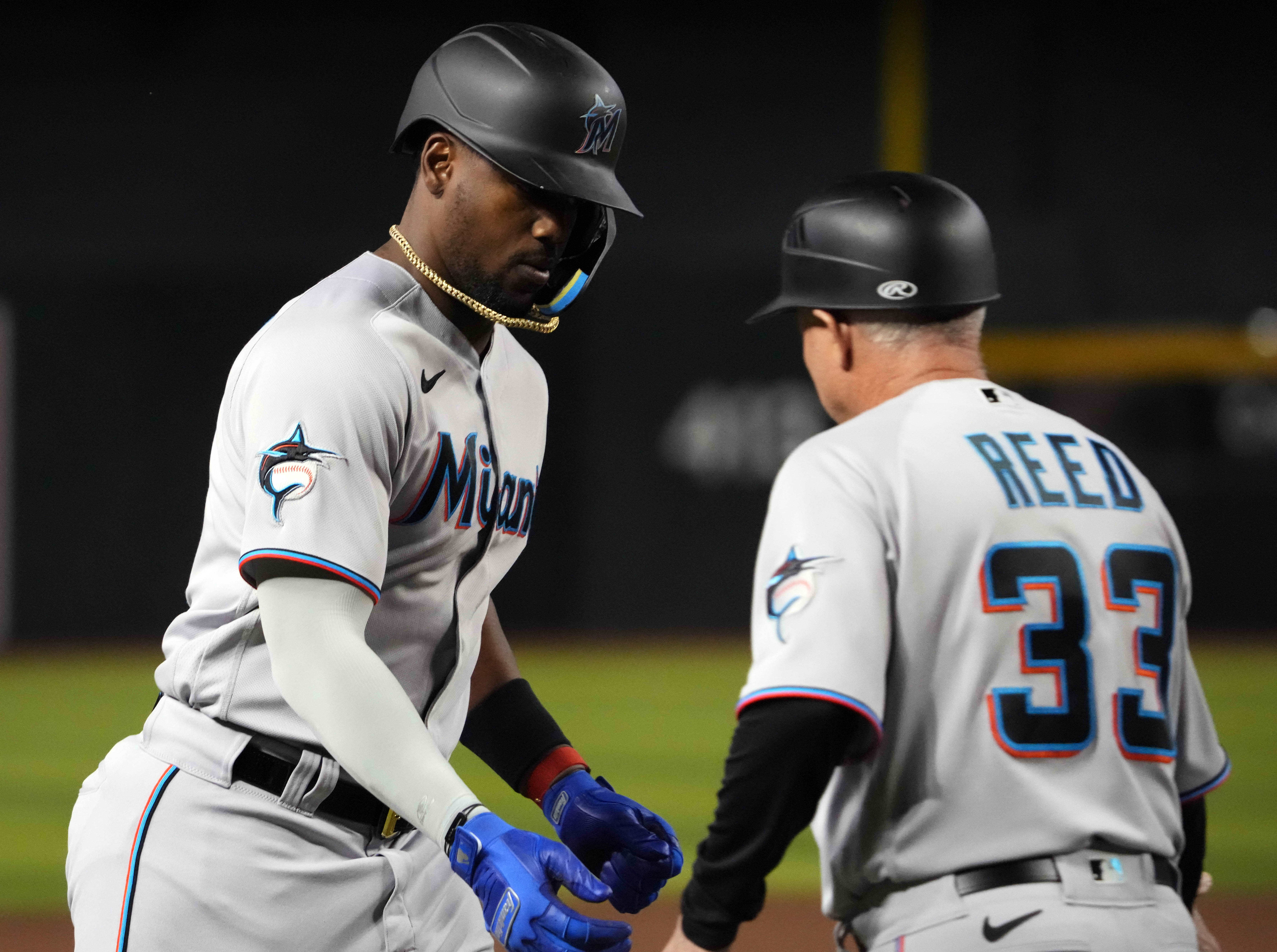 Marlins designated hitter Jorge Soler (12) slaps hands with Miami Marlins third base/infield coach Jody Reed (33) after hitting a home run against the Arizona Diamondbacks during the fifth inning at Chase Field.