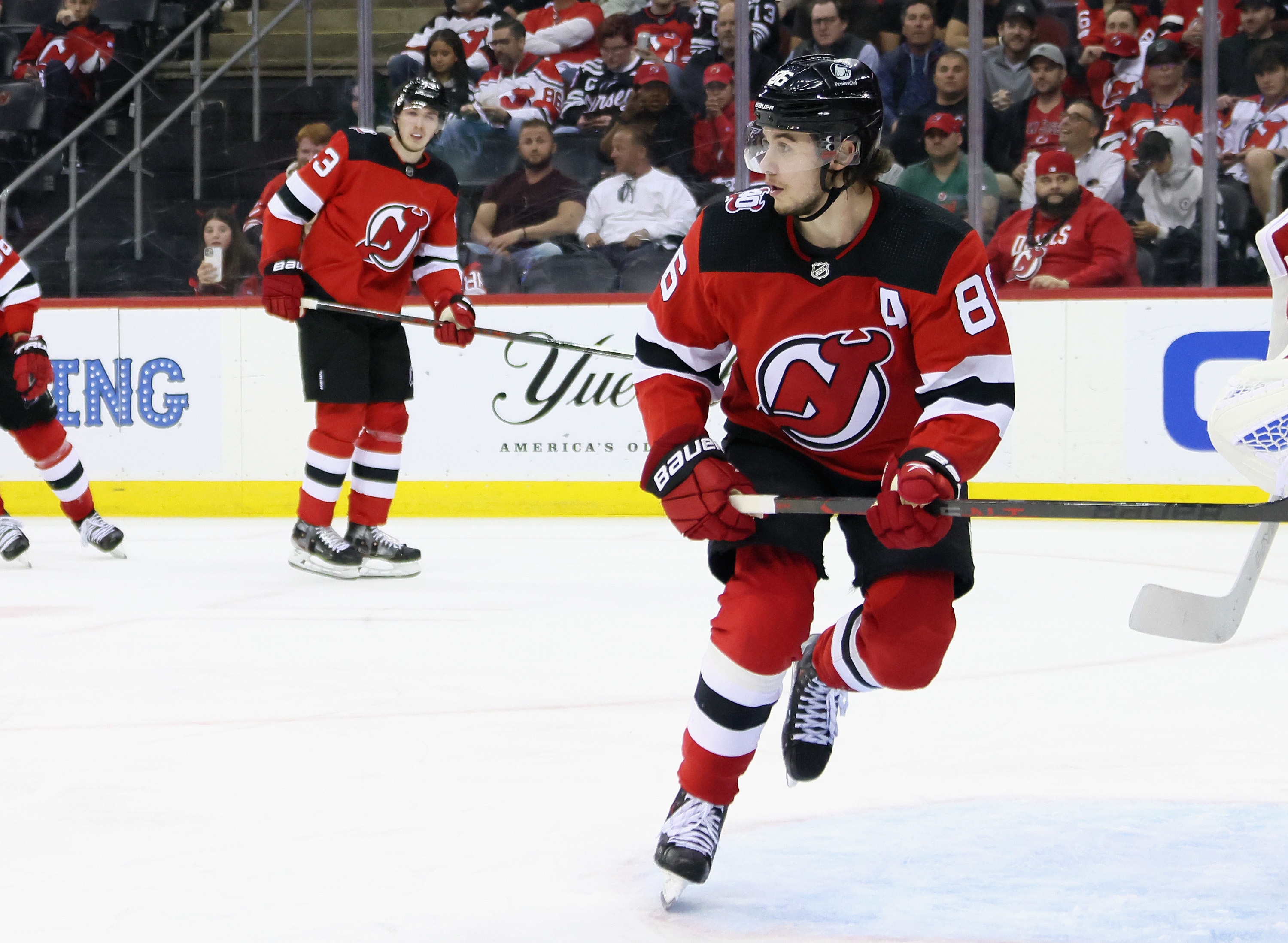 Luke Hughes #43 and Jack Hughes #86 of the New Jersey Devils skate against the Carolina Hurricanes in Game Four of the Second Round of the 2023 Stanley Cup Playoffs at Prudential Center on May 09, 2023 in Newark, New Jersey.