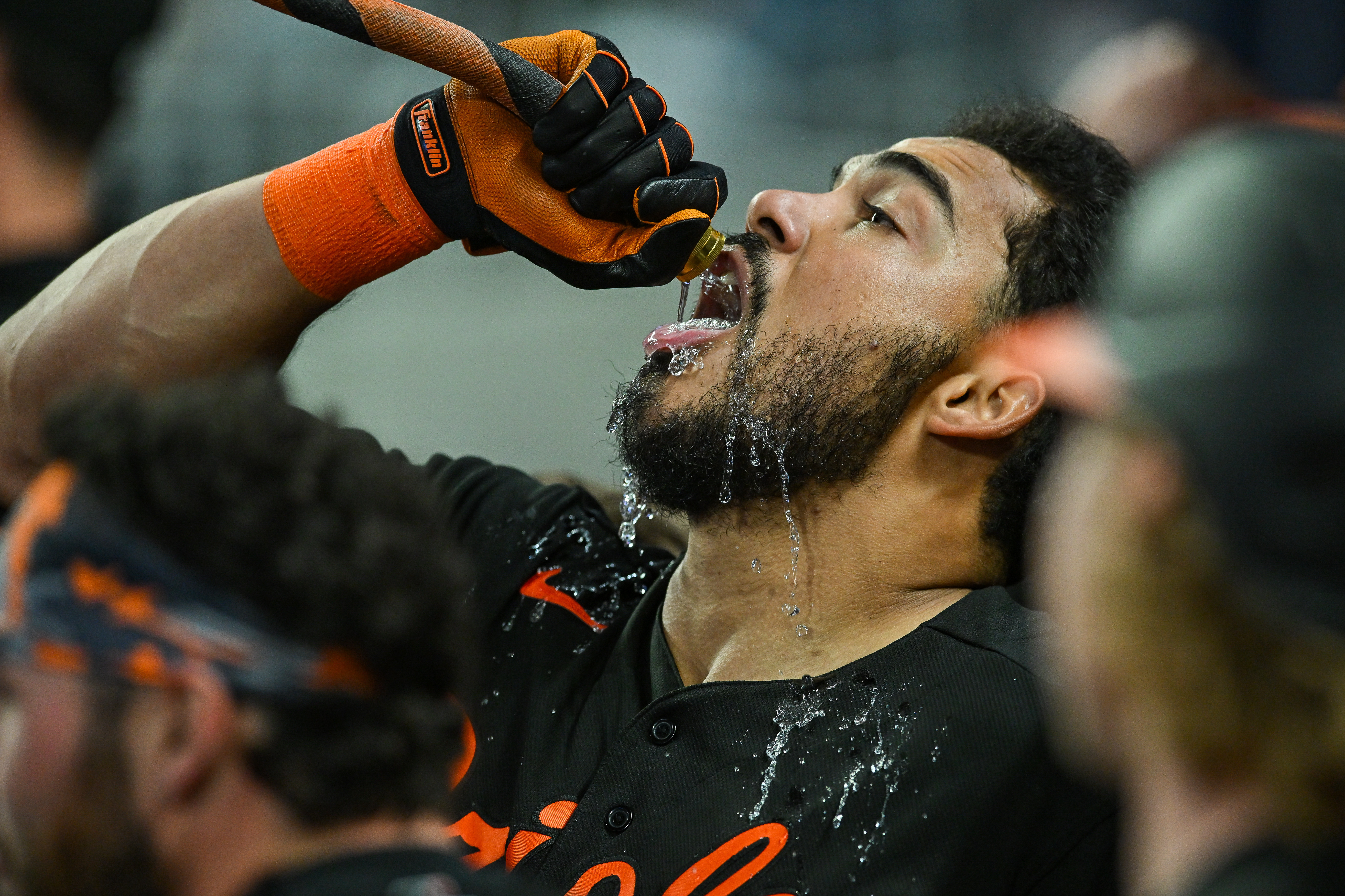 Orioles player Anthony Santander drinks water from a hose
