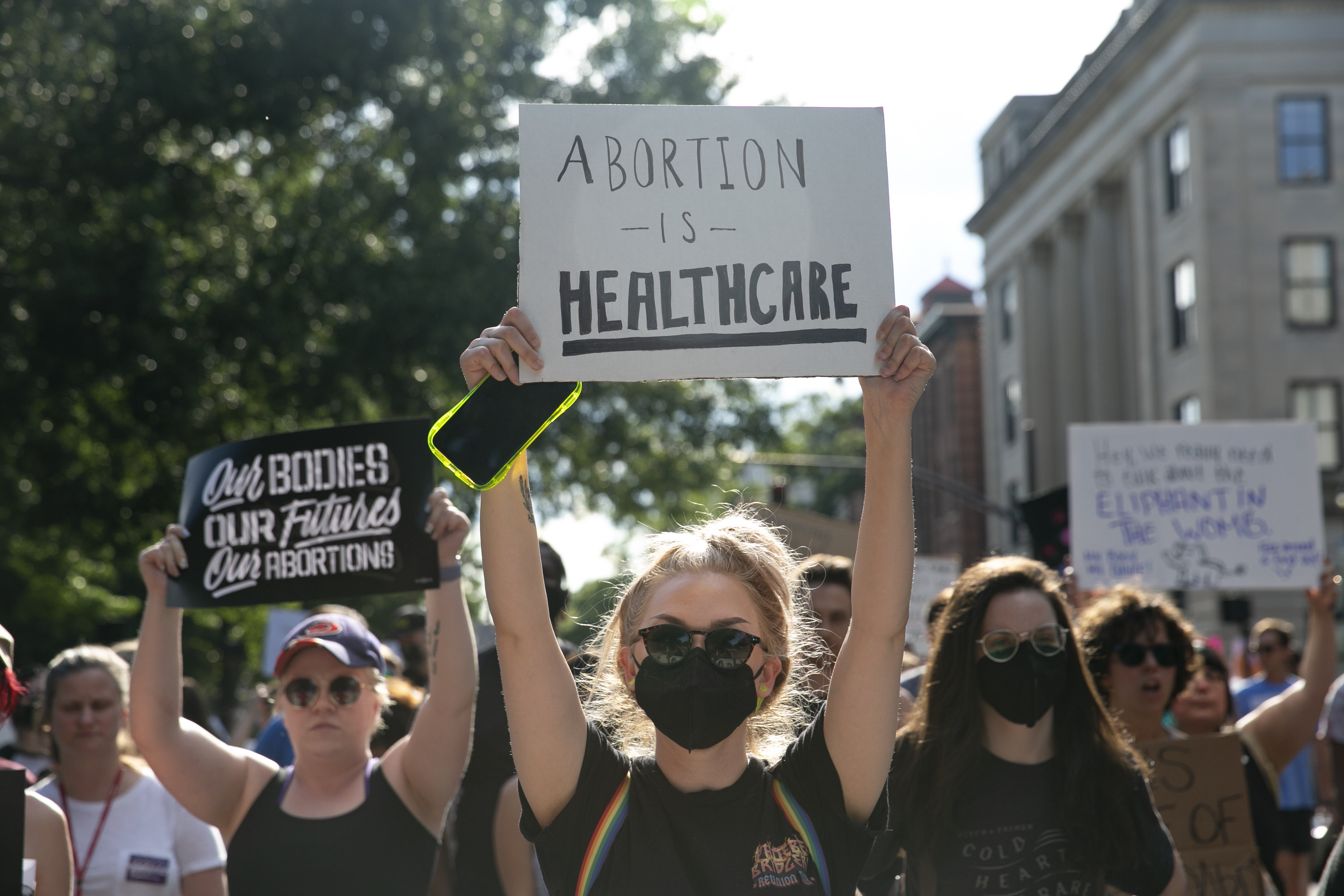 A protester in a crowd holds up a sign that reads “Abortion is healthcare.”