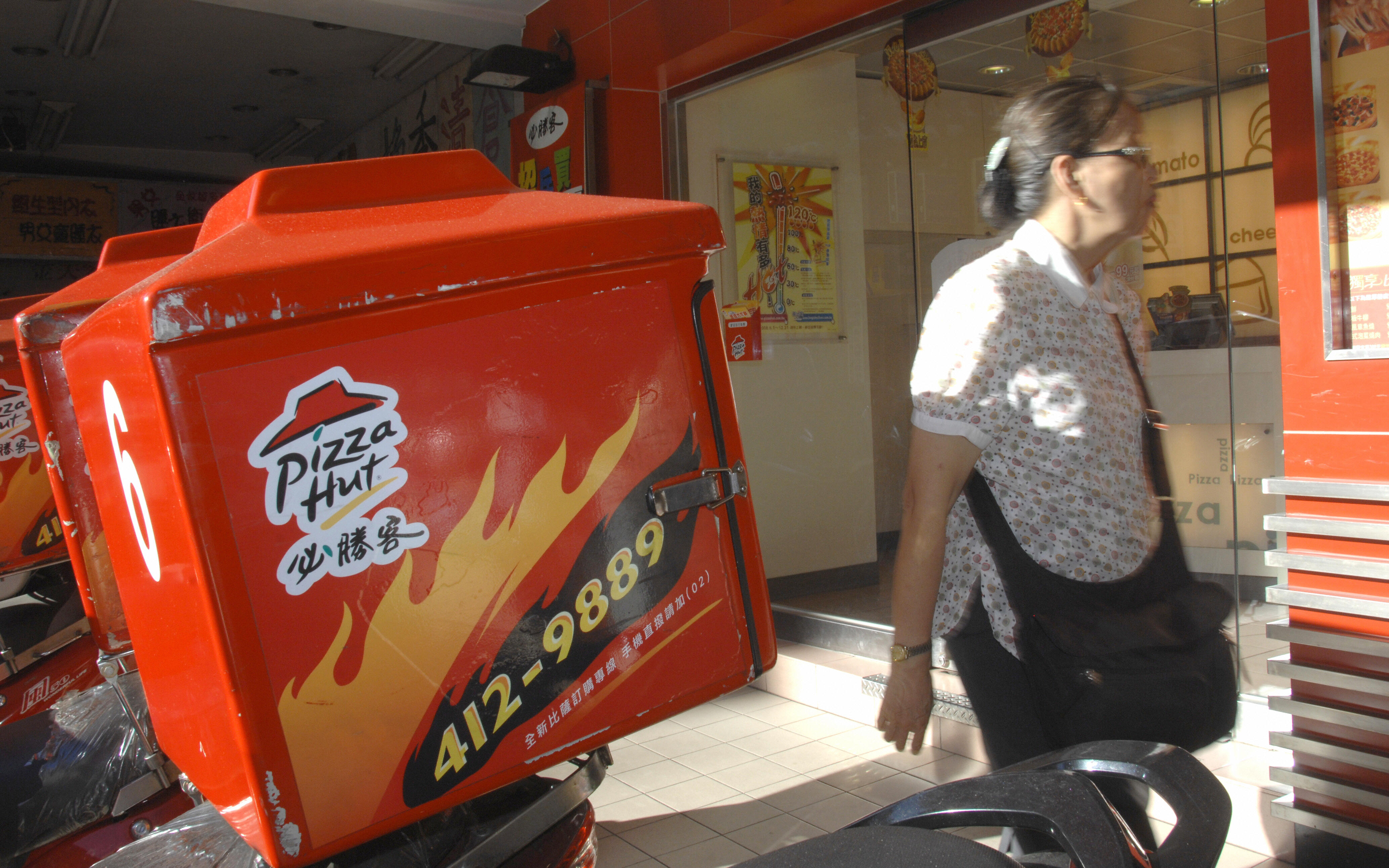 A woman walks by a Pizza Hut outlet in T