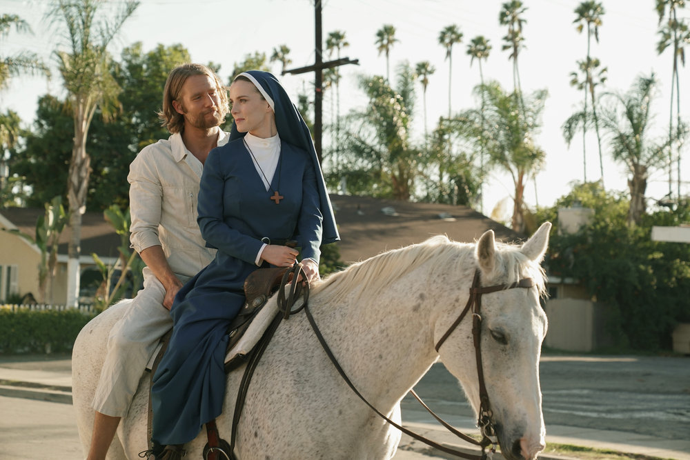 Simone (Betty Gilpin) and Wiley (Jake McDormand) sit on the back of a horse in a still from Mrs Davis season 1