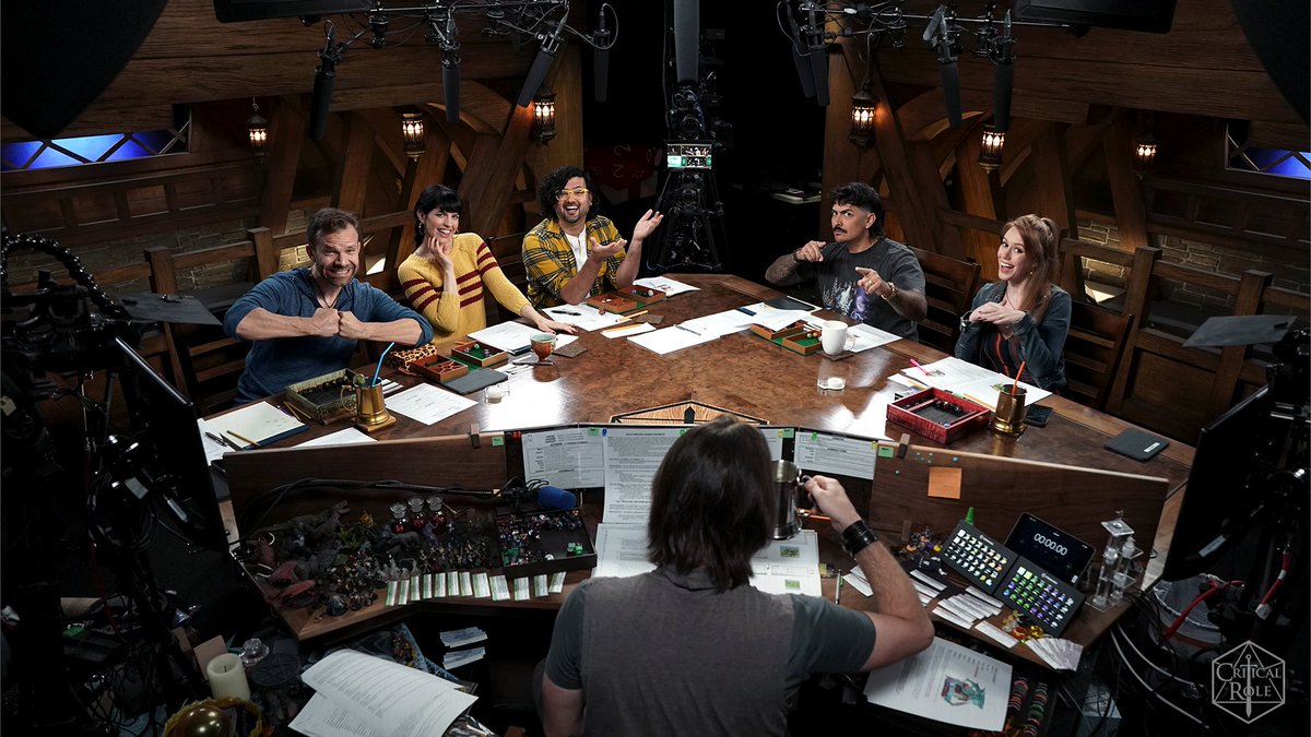 The Critical Role cast around a table recording