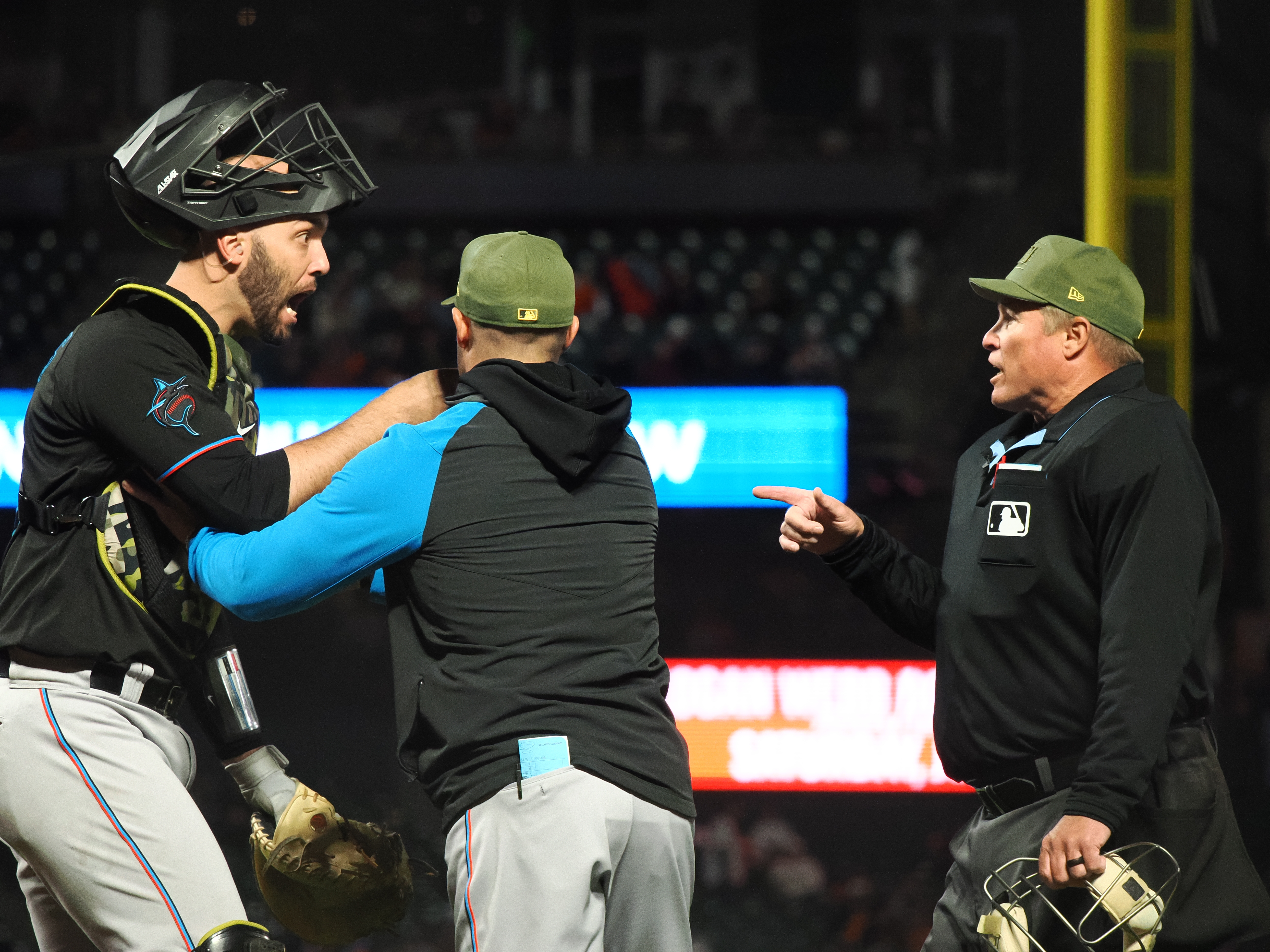 Miami Marlins catcher Jacob Stallings (58) is held back by manager Skip Schumaker (55) as he questions the call by home plate umpire Marvin Hudson (51) before being ejected during the eighth inning against the San Francisco Giants at Oracle Park.