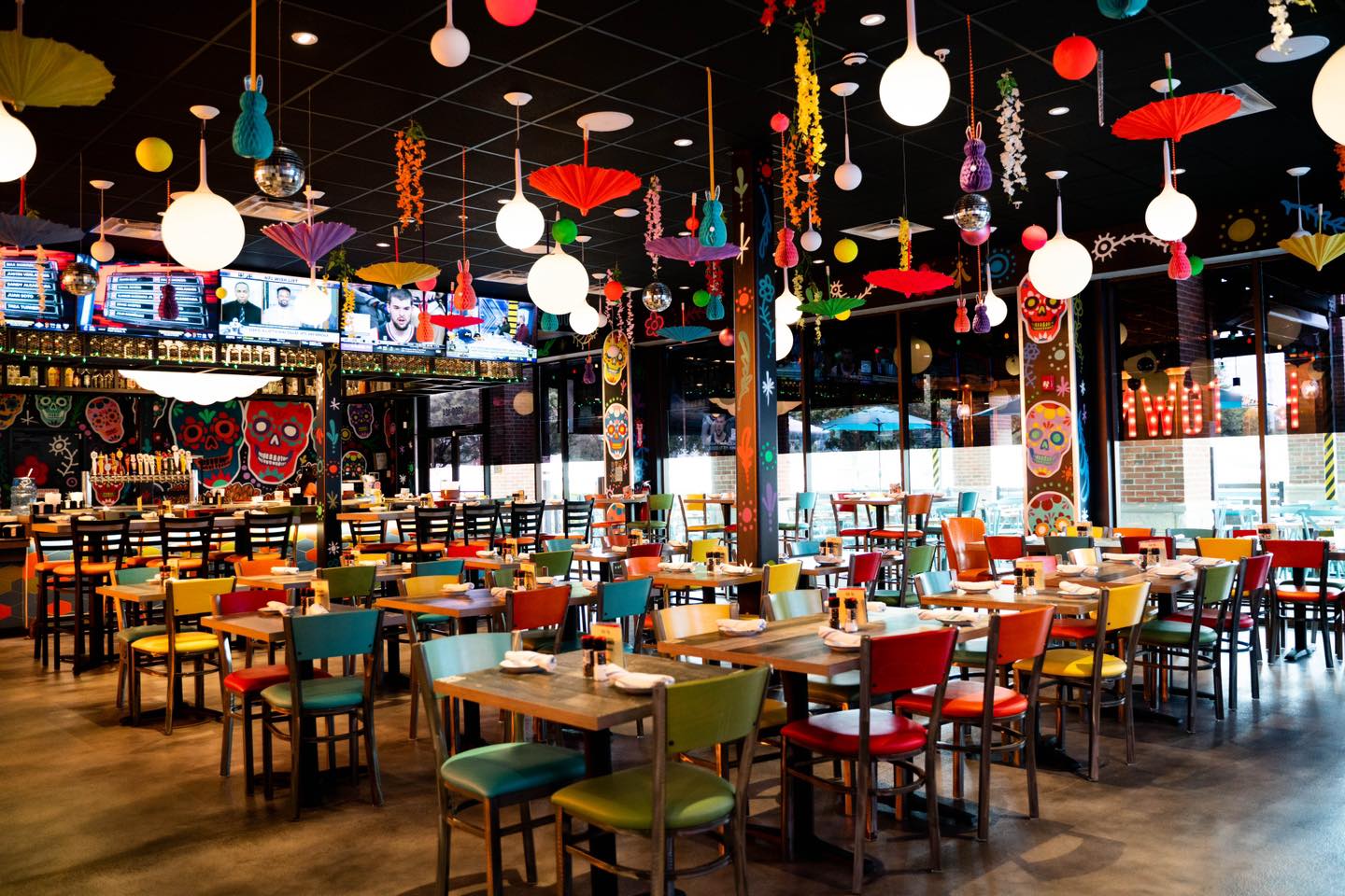 The colorful dining room at Valencia’s Tex-Mex Garage with skull-themed wallpaper and hanging ornaments from the ceiling.