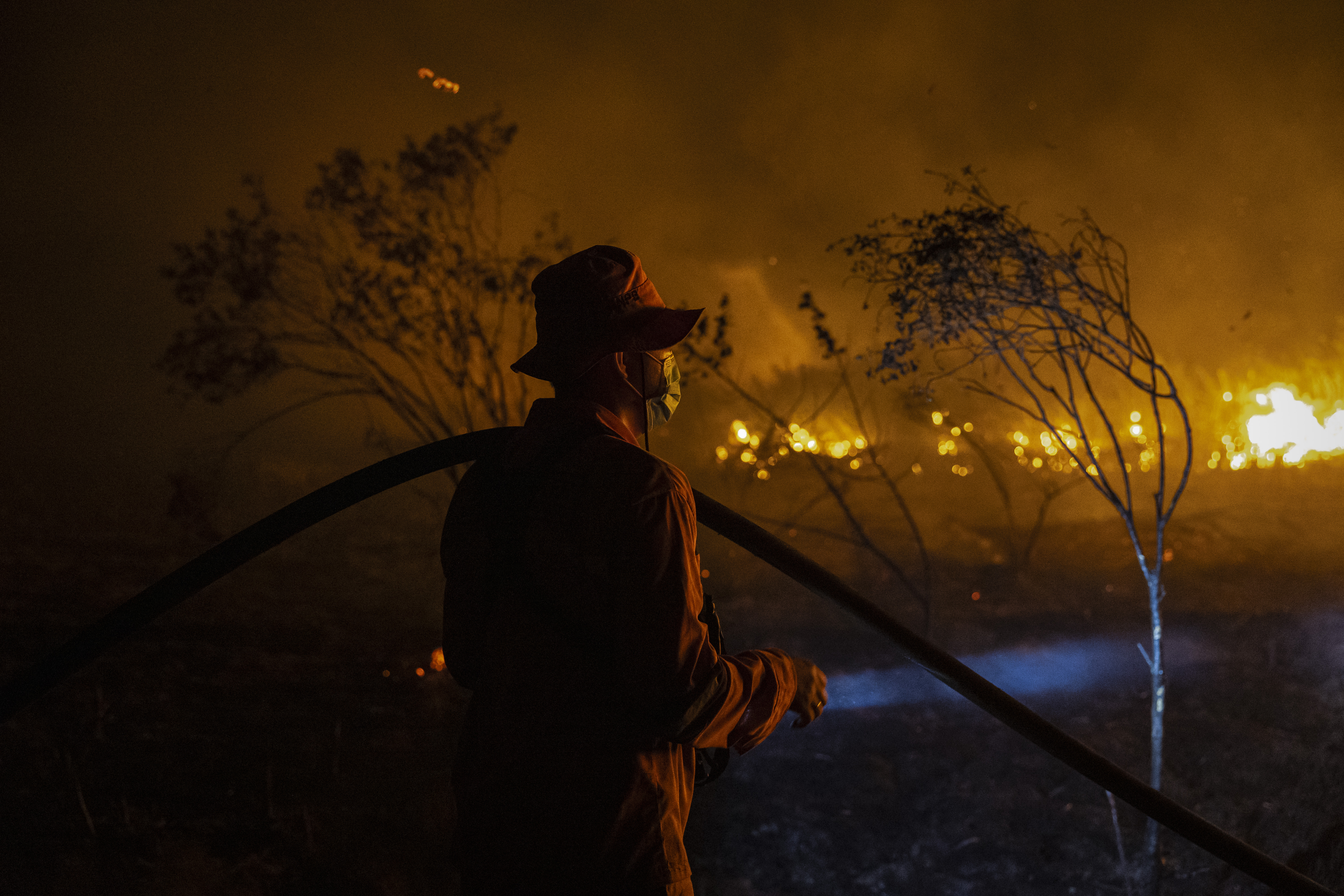 A firefighter works to extinguish a wildfire on burned peatland and fields on September 23, 2023 in South Sumatra, Indonesia.