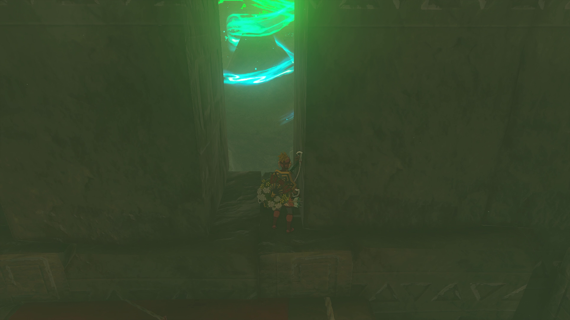 Link in the Yiga Clan armor standing in front of a shrine, visible through an opening in the wall in Tears of the Kingdom