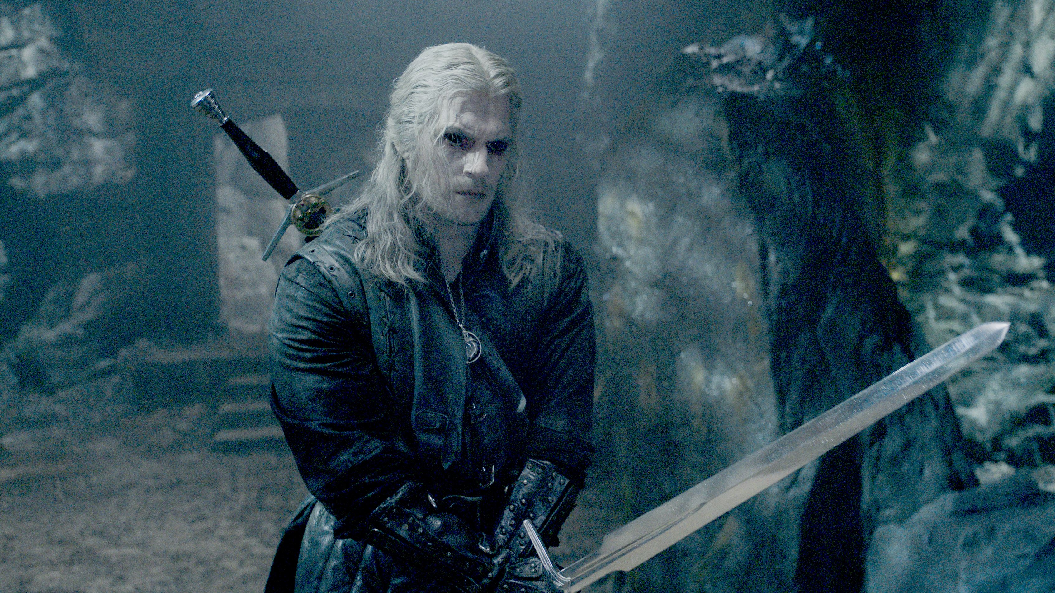 Geralt (Henry Cavill) with his sword drawn and his jet-black Witcher eyes in a still from The Witcher season 3