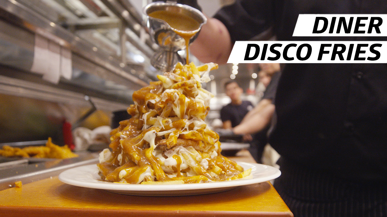 A plate of french fries piled high, topped with melted mozzarella cheese and doused in gravy