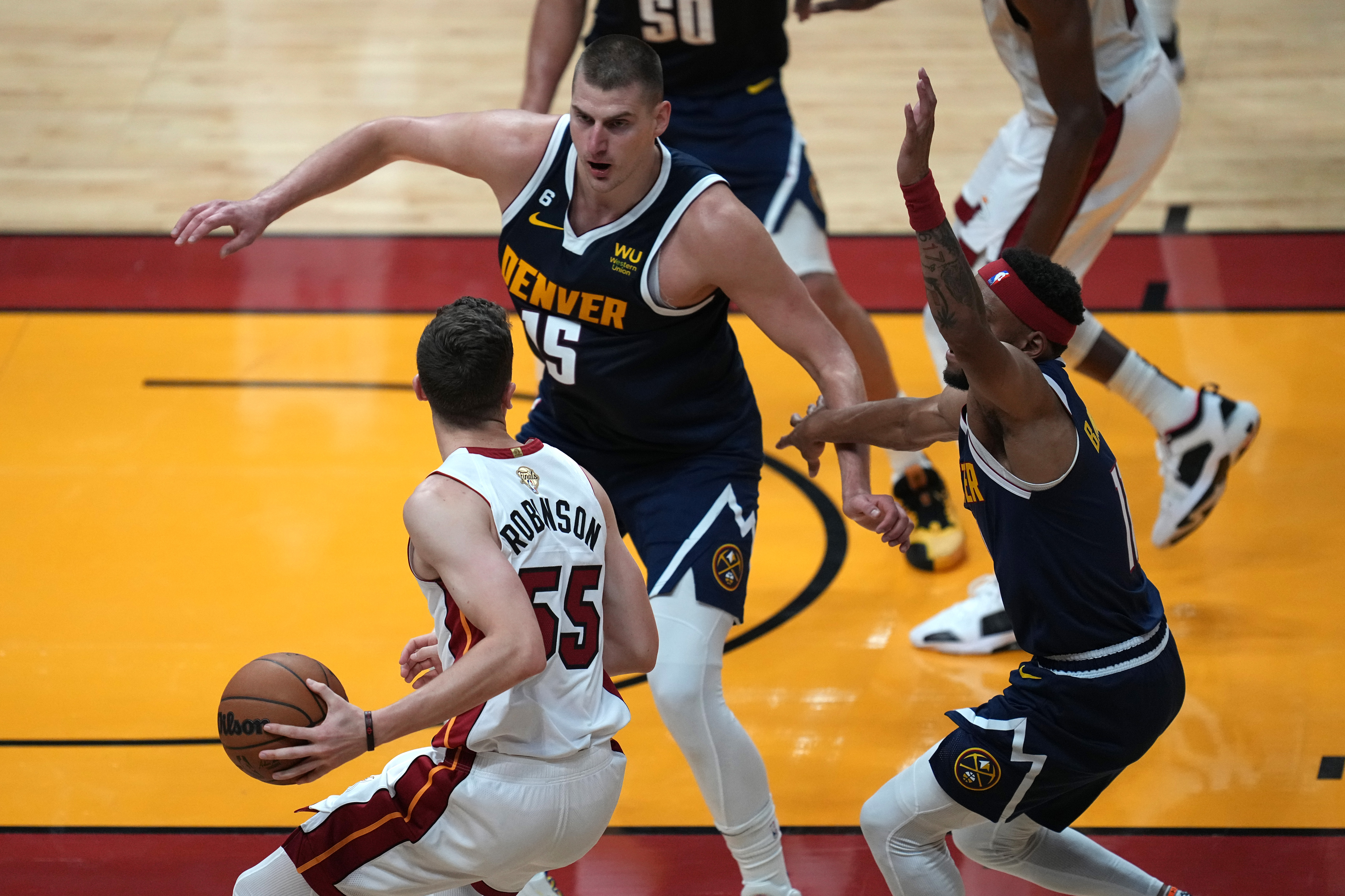 Miami Heat forward Duncan Robinson (55) dribbles the ball while defended by Denver Nuggets center Nikola Jokic (15) during the first half in game four of the 2023 NBA Finals at Kaseya Center.&nbsp;