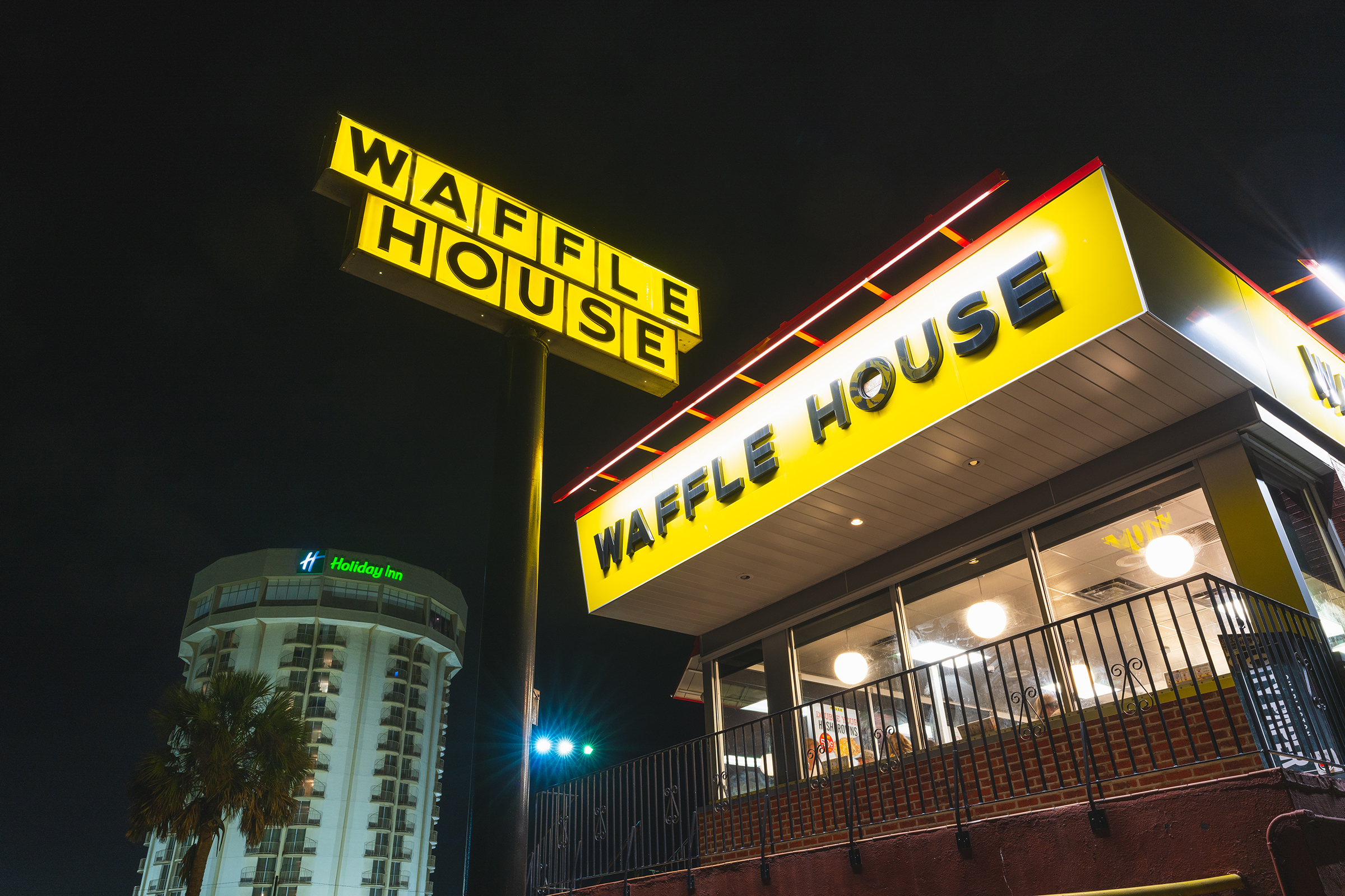 A yellow sign reading “Waffle House.”
