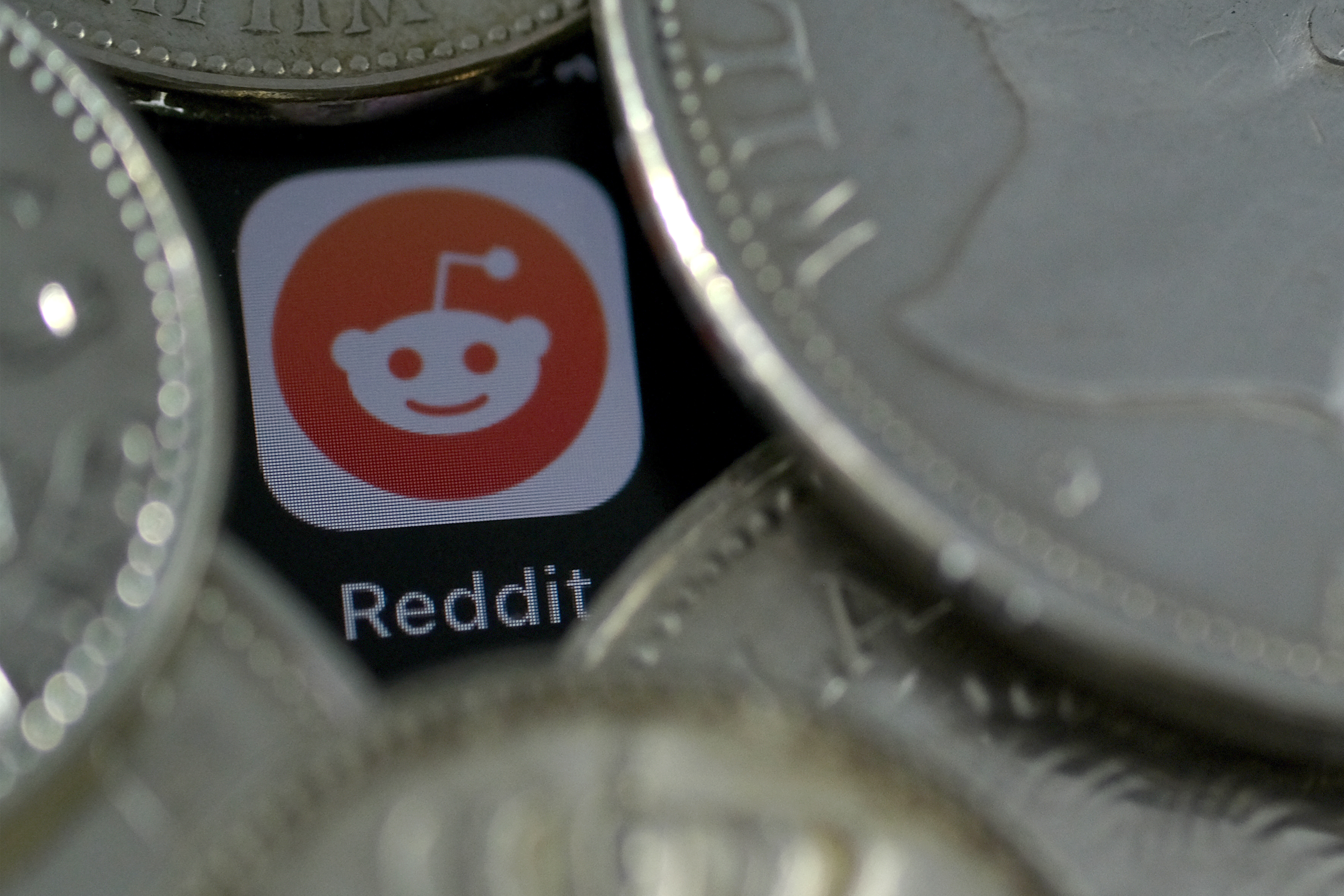 A Reddit icon surrounded by coins.