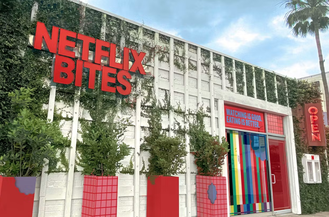 A facade of a Netflix-themed pop-up in Los Angeles with foliage and signage.