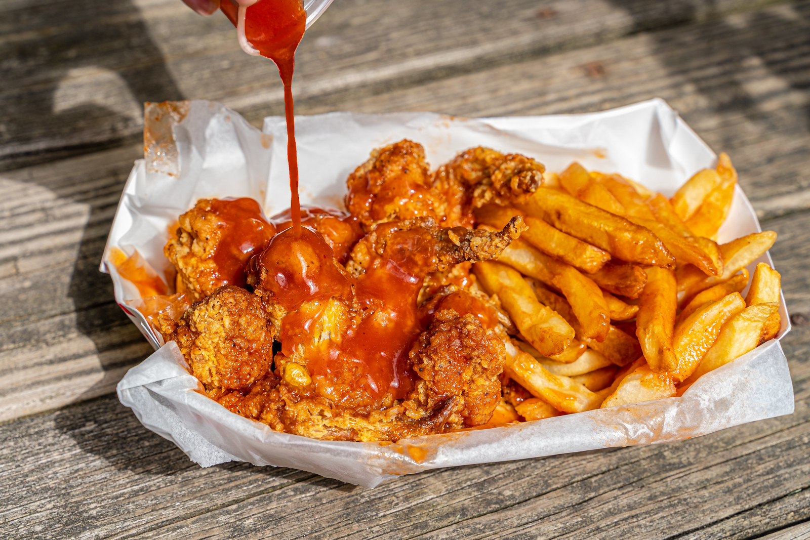 A basket of fried chicken with mild sauce.