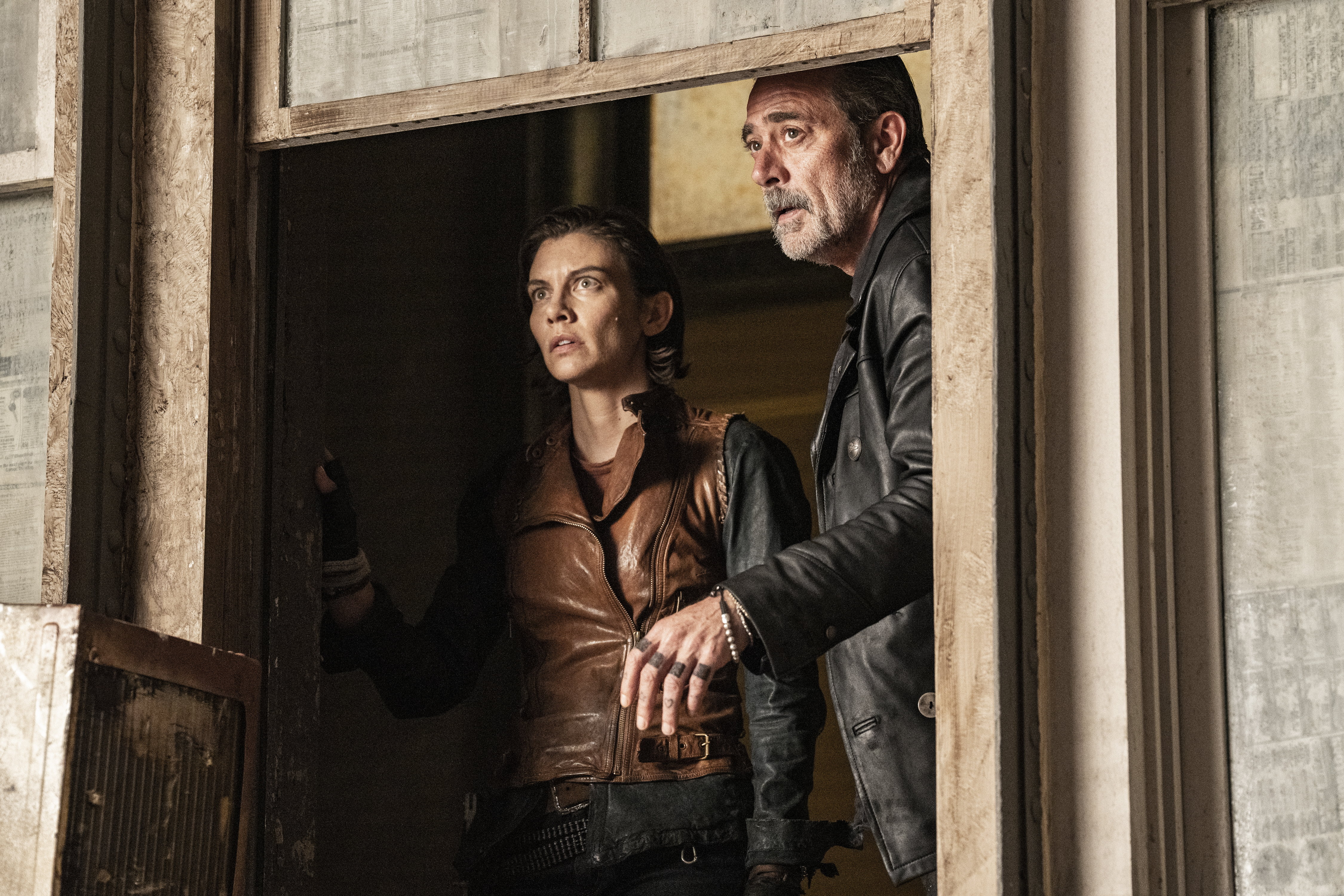 Maggie (Lauren Cohan) and Negan (Jeffrey Dean Morgan) looking out a window concerned in a still from The Walking Dead: Dead City
