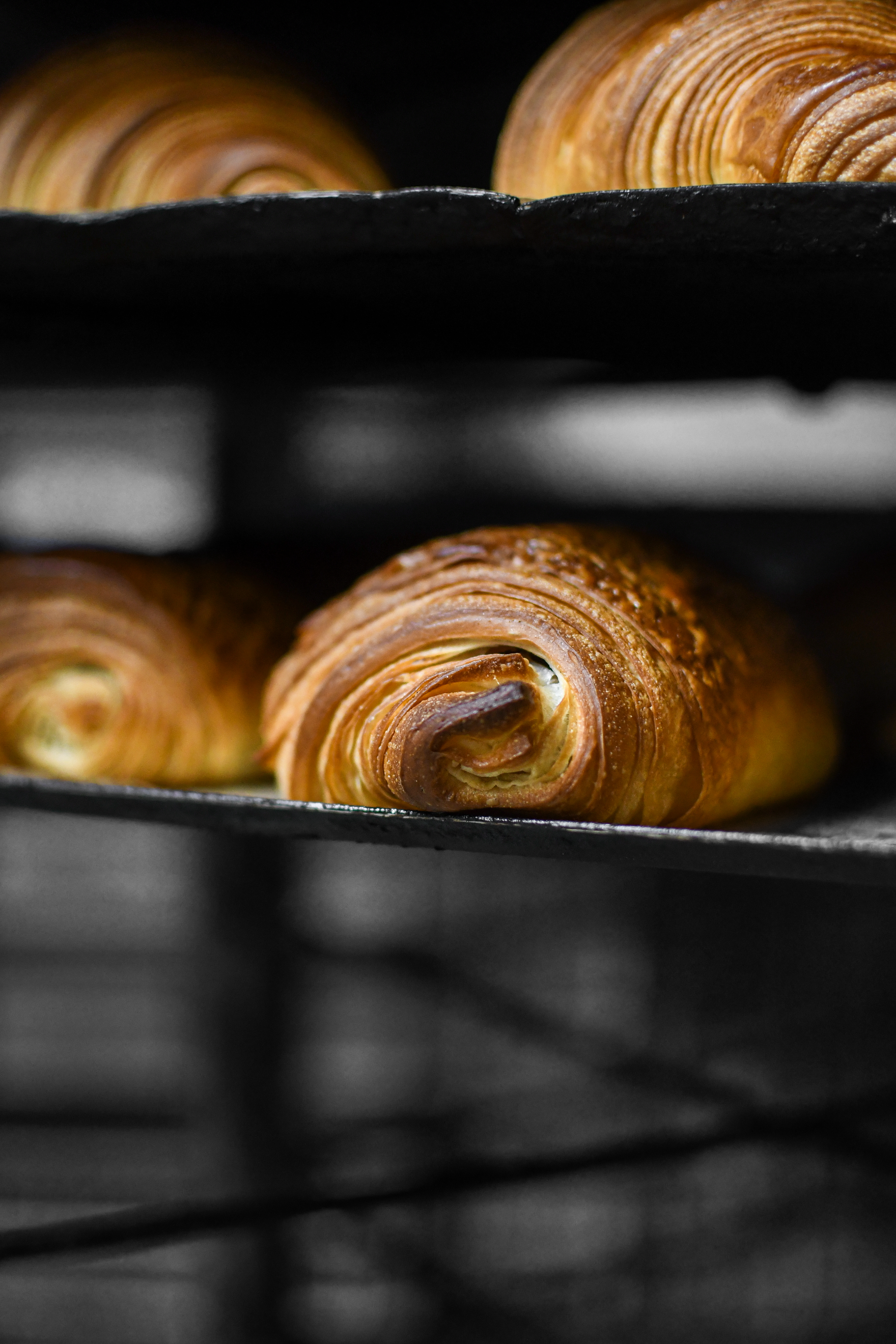 Croissants cooling on a rack at Boulangerie Veziano in Antibes, France.