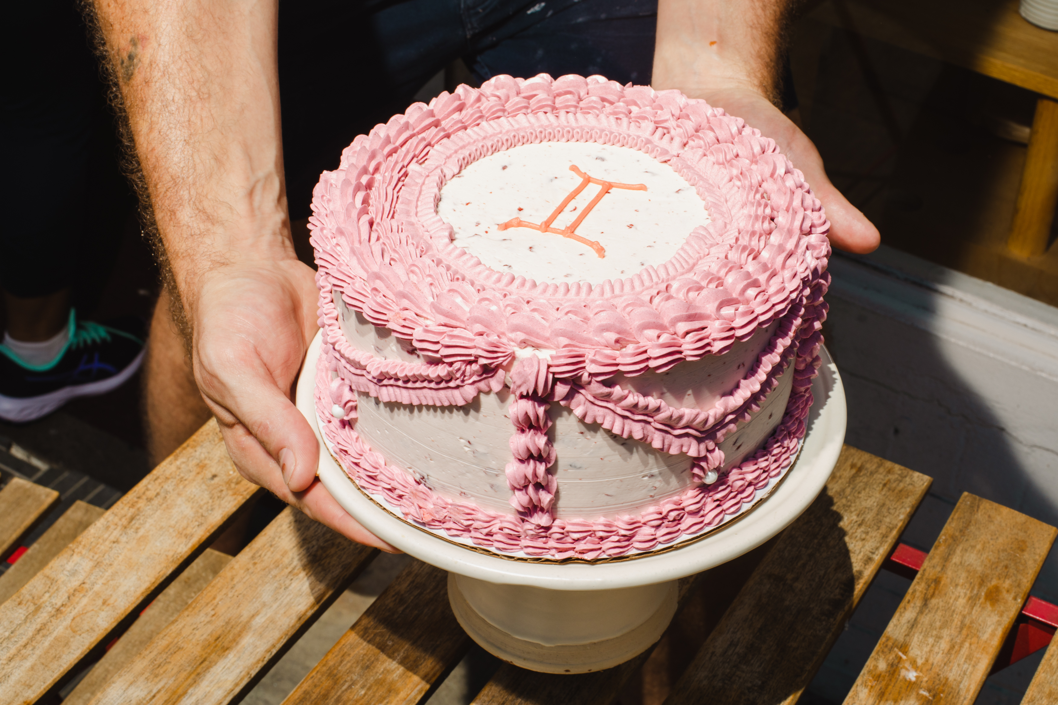A birthday cake with pink trim.