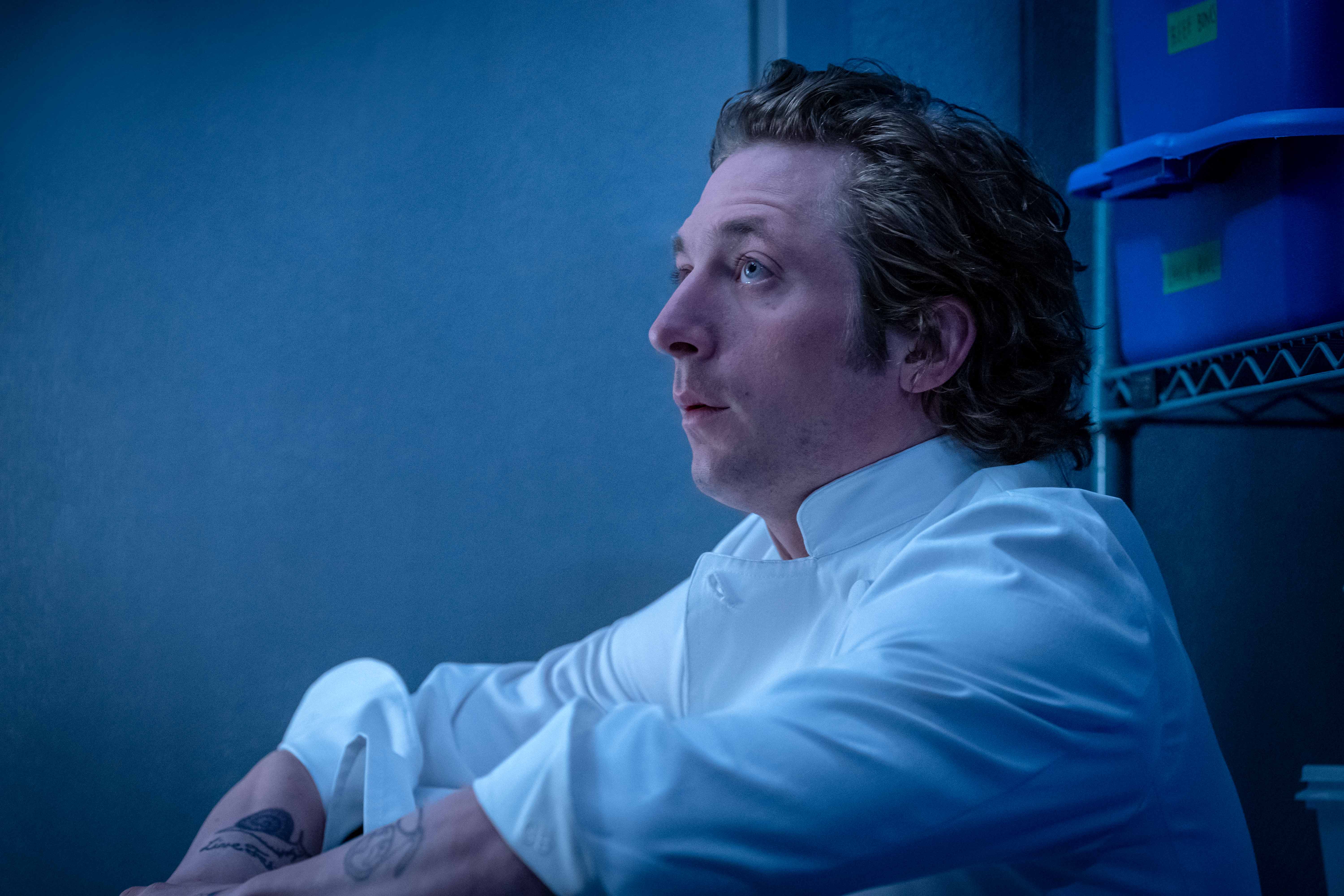 Jeremy Allen White as Carmine “Carmy” Berzatto in “The Bear,” sits in a walk-in refrigerator in front of milk crates.