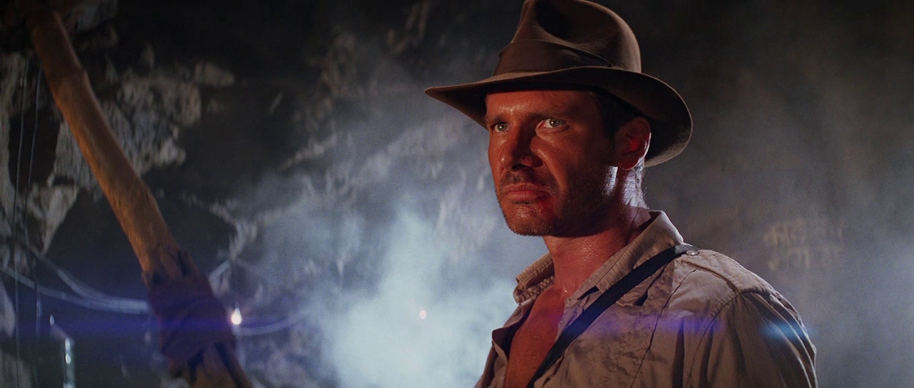 Harrison Ford scowls as Indiana Jones in his iconic outfit.
