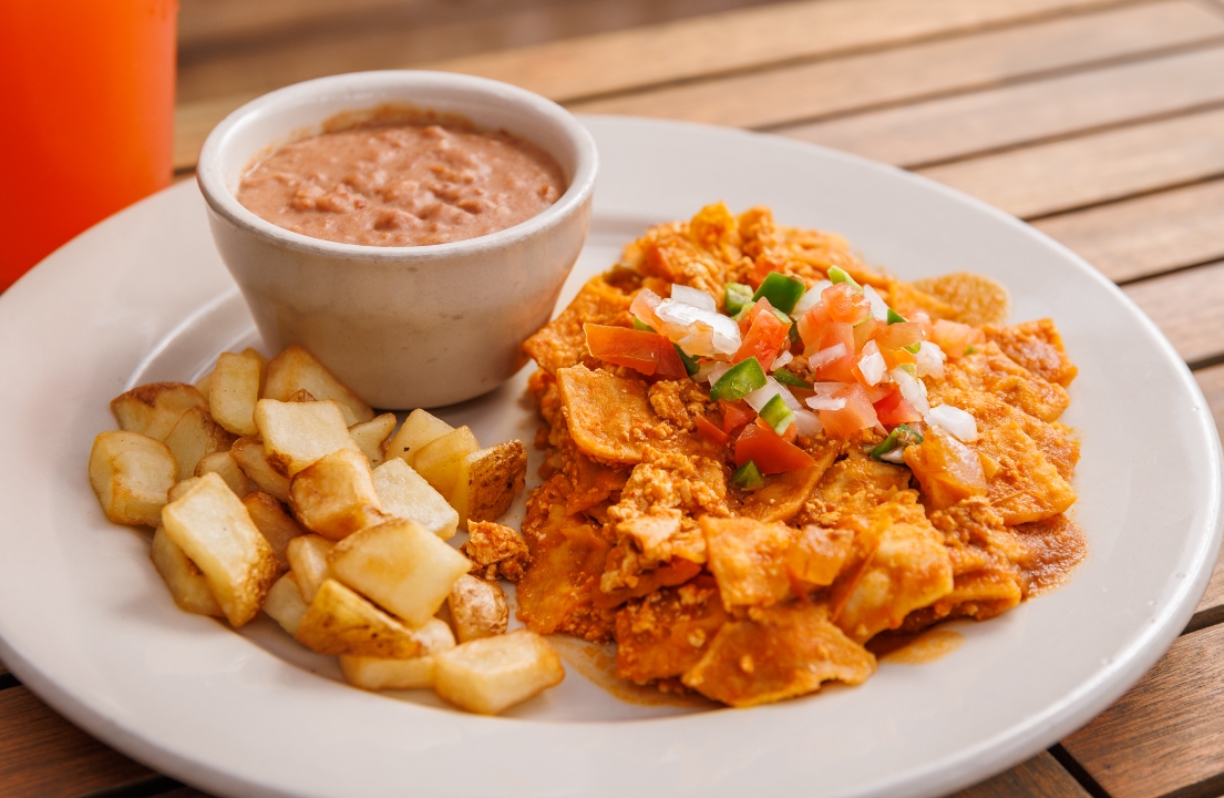 A plate of vegan migas and potatoes and a bowl of refried beans.